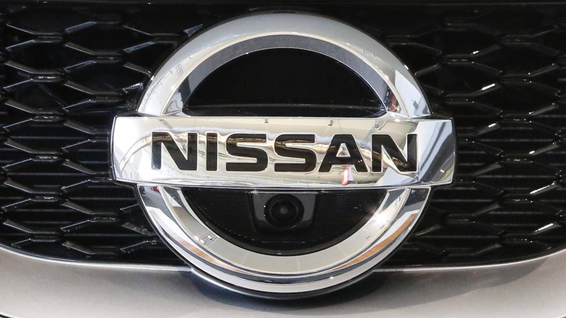 This Feb. 11, 2016, photo shows a Nissan emblem on a 2016 Nissan automobile at the Pittsburgh International Auto Show in Pittsburgh. Japanese automaker Nissan Motor Co. is reporting a 136.4 billion yen ($30.7 million) profit for the fiscal quarter through June, down nearly 11 percent from the same period a year ago. (AP Photo/Gene J. Puskar)