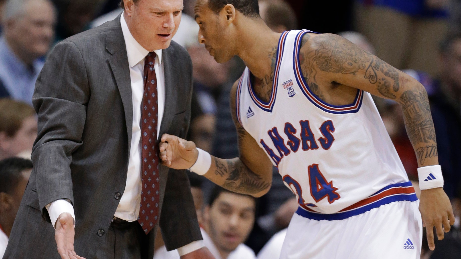 Kansas coach Bill Self talks with guard Travis Releford (24) during the first half of an NCAA college basketball game against TCU in Lawrence, Kan., Saturday, Feb. 23, 2013. (AP Photo/Orlin Wagner)