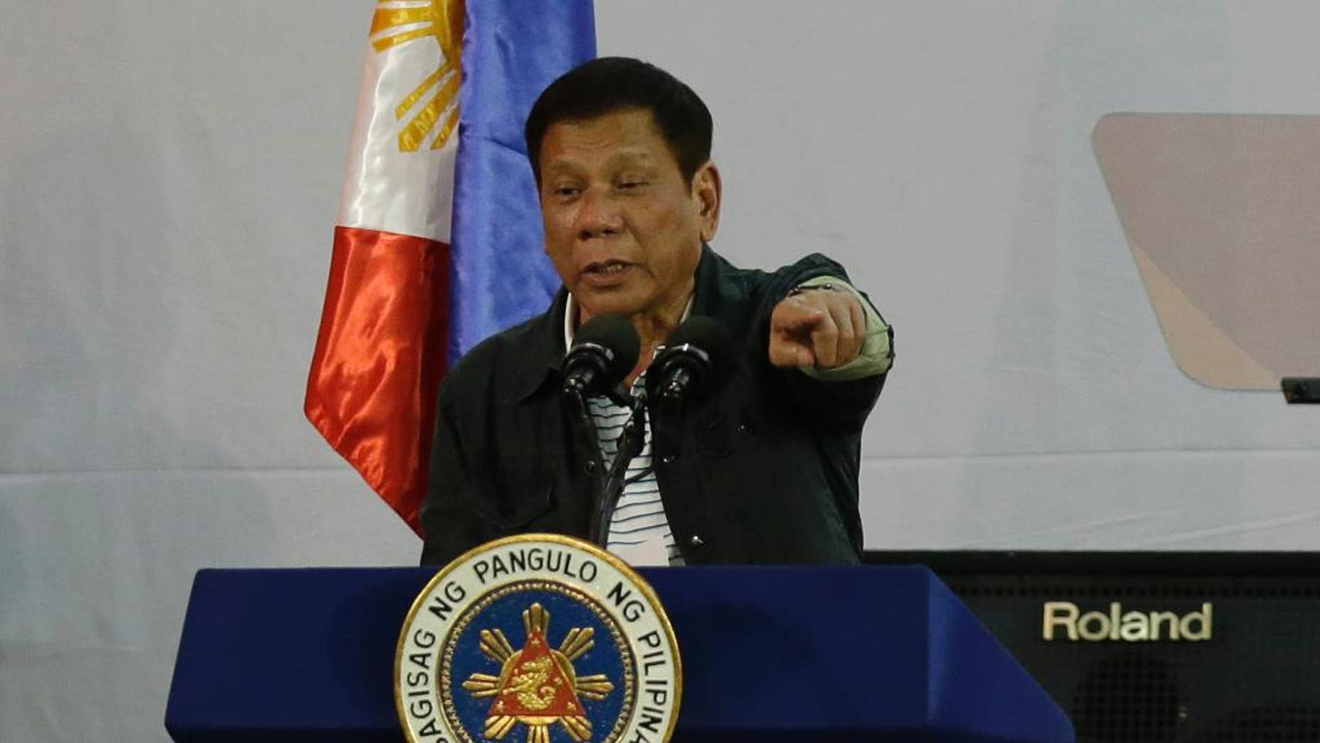 FILE - In this Thursday, June 30, 2016, file photo, Philippine President Rodrigo Duterte gestures as he delivers his speech before a solidarity dinner with the poor event at a slum area in Manila, Philippines. New Philippine President Rodrigo Duterte on Tuesday July 5, 2016, named five active and retired police generals as protectors of drug syndicates, and sacked those still in service. (AP Photo/Aaron Favila, File)