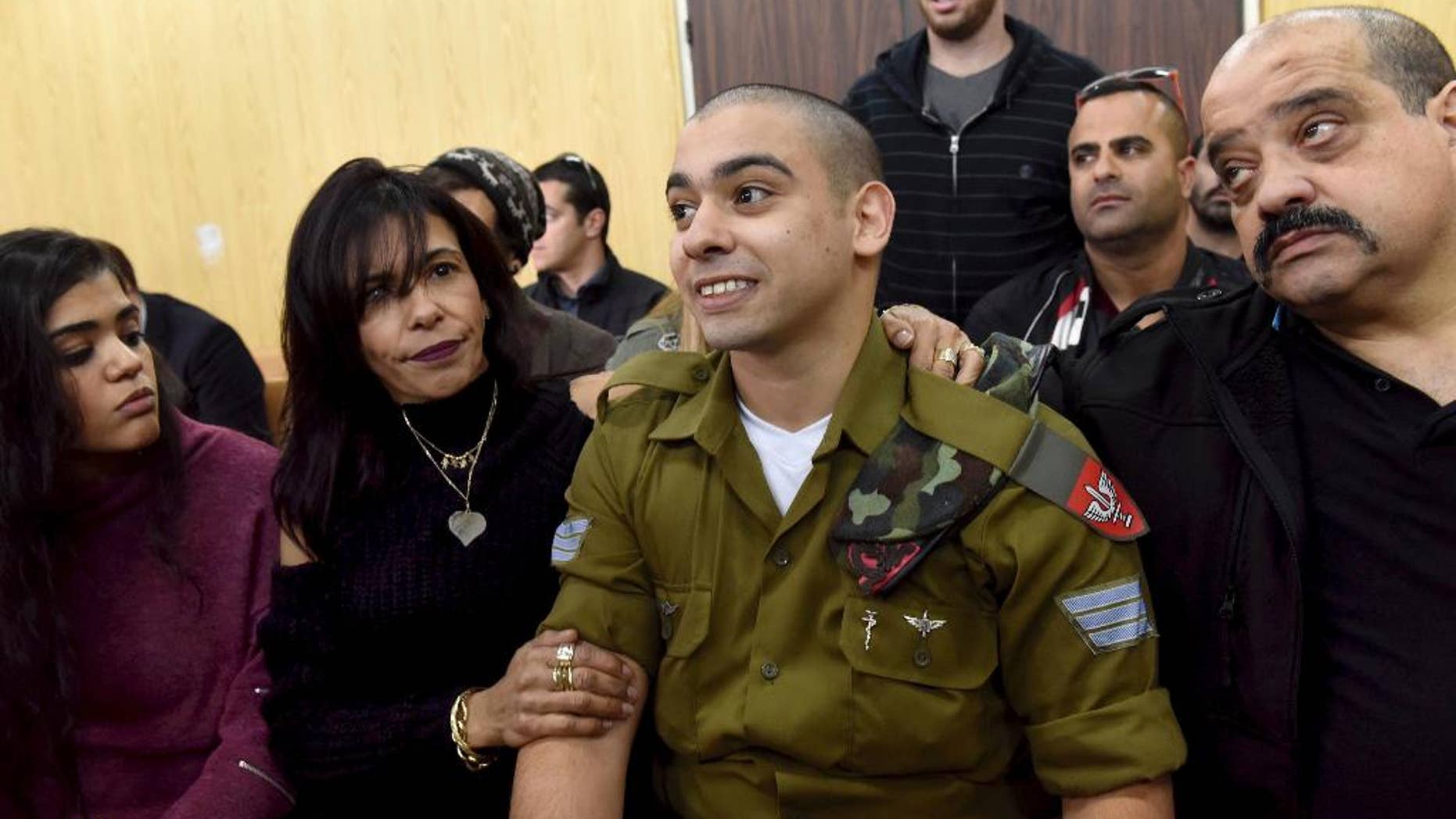 FILE -- In this January 24, 2017 file photo, Israeli soldier Sgt. Elor Azaria attends a sentencing hearing in the military court surrounded by his family, in Tel Aviv, Israel. The Israeli army said a military court on Tuesday, Feb, 21, 2017, will sentence a soldier convicted of manslaughter for fatally shooting a wounded Palestinian assailant. Azaria faces a maximum sentence of 20 years, though analysts expect him to receive less than that. (Debbie Hill, Pool via AP, File)