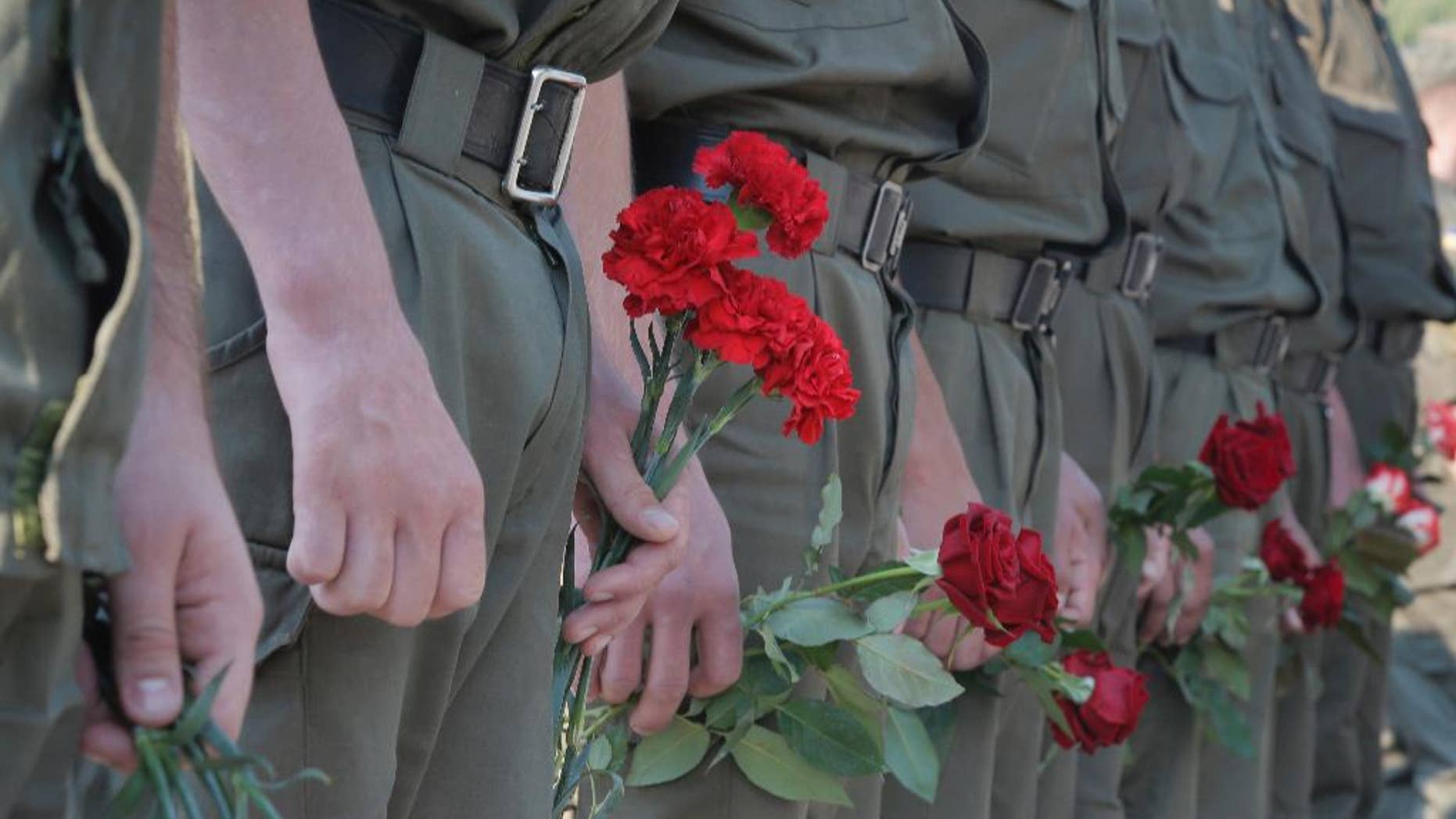 Ukrainian soldiers wait for their turn to pay the last tribute to a coffin bearing the body of National Guard soldier Igor Derbin who was killed in a Monday clash, at a military base in Novi Petrivtsi outside Kiev, Ukraine, Wednesday, Sept. 2, 2015. Ukrainian police say 141 people remain hospitalized after a nationalist protest in Kiev turned violent, with 10 of the injured in serious condition. Three officers died from their wounds. (AP Photo/Efrem Lukatsky)