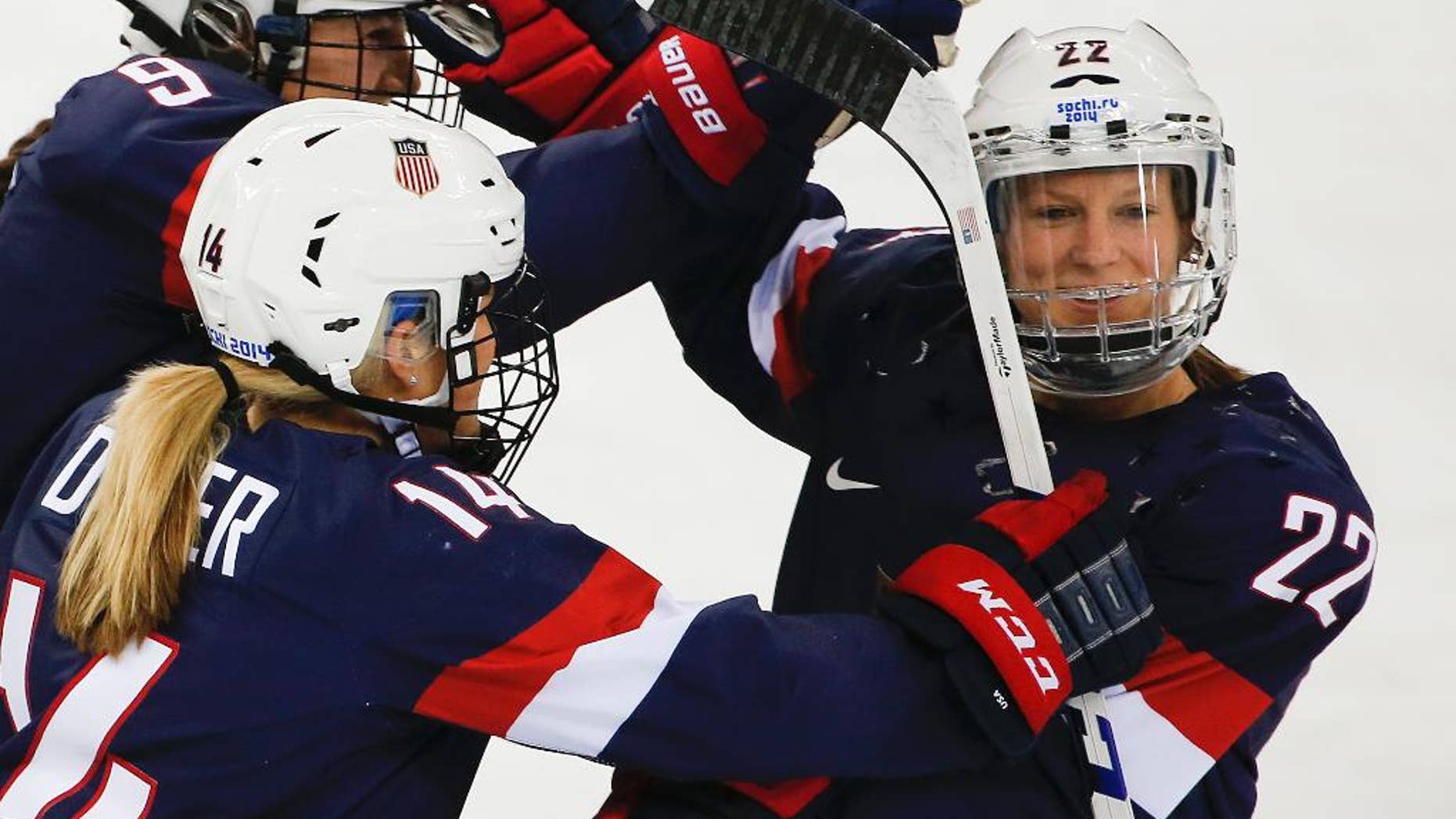 FILE - In this Feb. 17, 2014, file photo, Kacey Bellamy of the United States, right, is congratulated by teammates after scoring a goal against Sweden during the first period of the 2014 Winter Olympics women's semifinal ice hockey game in Sochi, Russia. The U.S. women's hockey team is threatening to boycott the world championships because of a wage dispute. The team announced Wednesday that they will not participate in the International Ice Hockey Federation tournament that begins March 31, 2017, in Plymouth, Michigan. (AP Photo/Julio Cortez, File)