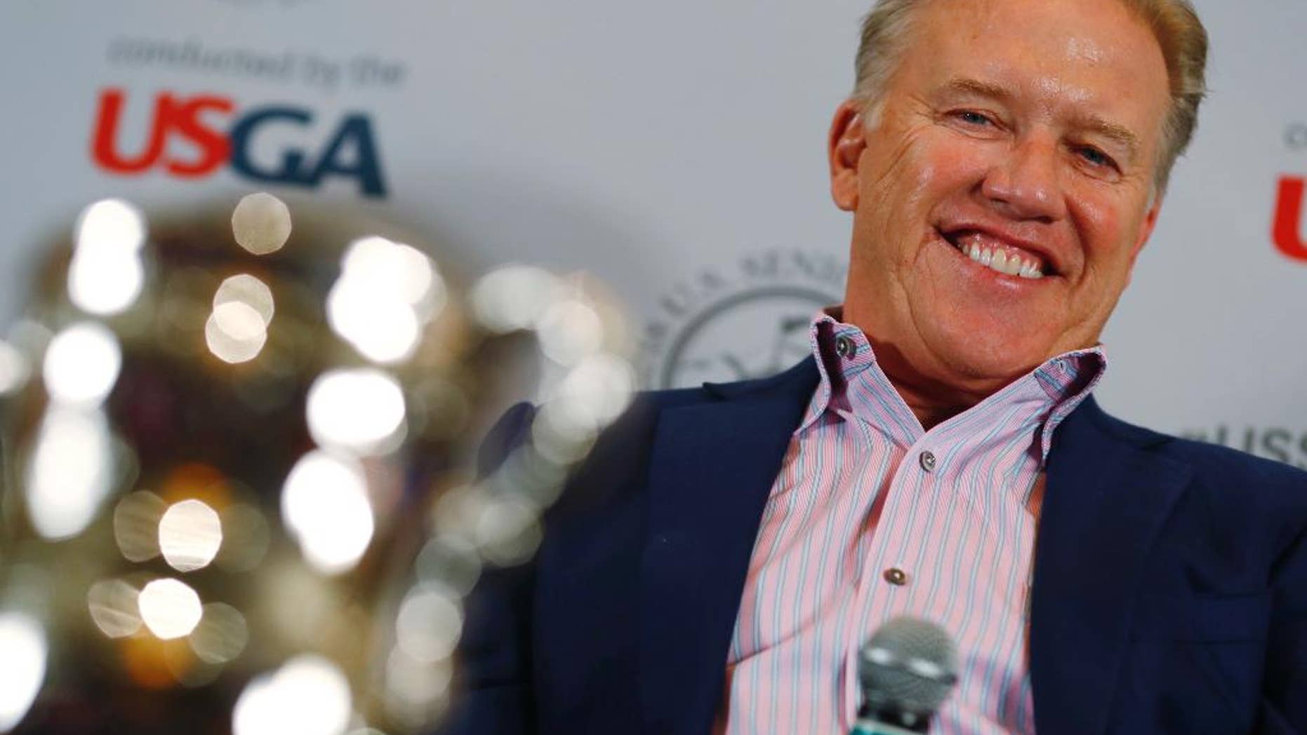 Denver Broncos general manager John Elway jokes with reporters after he was introduced as the honorary chairman of the 39th U.S. Senior Open, which will be held at the Broadmoor Golf Club in Colorado Springs, Colo., during a news conference at one of the retired football player's steakhouses on Tuesday, Nov. 15, 2016, in Denver. The 2018 U.S. Senior Open will run from June 28 through July 1 on the Broadmoor's East Course. (AP Photo/David Zalubowski)