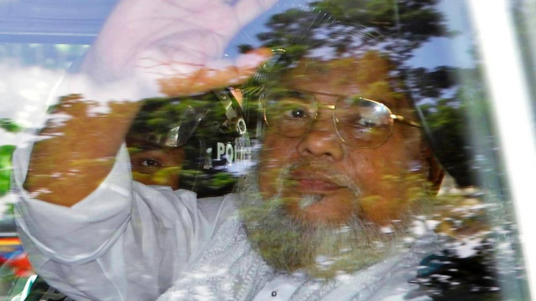 FILE - In this July 17, 2013, file photo, Ali Ahsan Mohammad Mojaheed, the secretary-general of Bangladesh's Jamaat-e-Islami party, waves from a police vehicle as he is brought to court in Dhaka, Bangladesh. Bangladesh's Supreme Court on Tuesday, June 16, 2015, upheld his death sentence for war crimes and crimes against humanity during the country's independence war against Pakistan in 1971. (AP Photo, File)