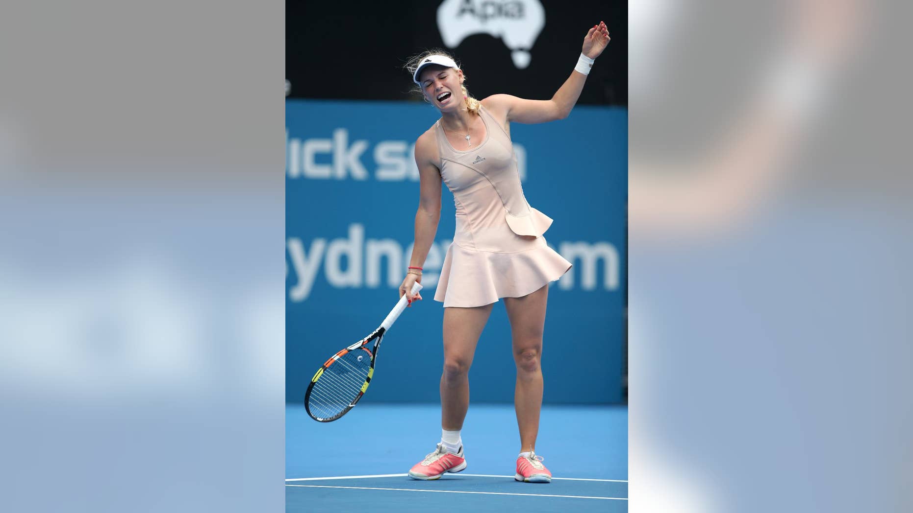 Caroline Wozniacki of Denmark reacts while playing Barbora Zahlavova Strycova of the Czech Republic during their match at the Sydney International tennis tournament in Sydney, Monday, Jan. 12, 2015. Wozniacki retired from the match with a wrist injury. (AP Photo/Rick Rycroft)