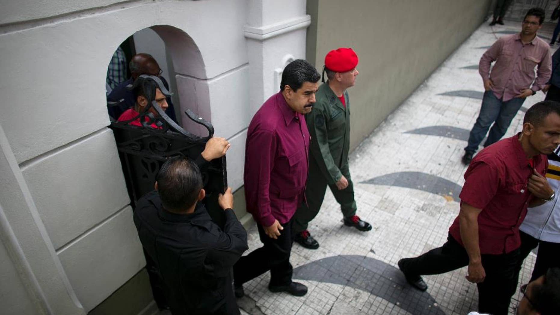 Venezuela's President Nicolas Maduro exits an area of Miraflores presidential palace to greet supporters in Caracas, Venezuela, Friday, Oct. 28, 2016. For the most part, residents of Venezuela's capital ignored calls to stay home Friday to protest Maduro, handing a rare victory to the embattled leader. (AP Photo/Ariana Cubillos)