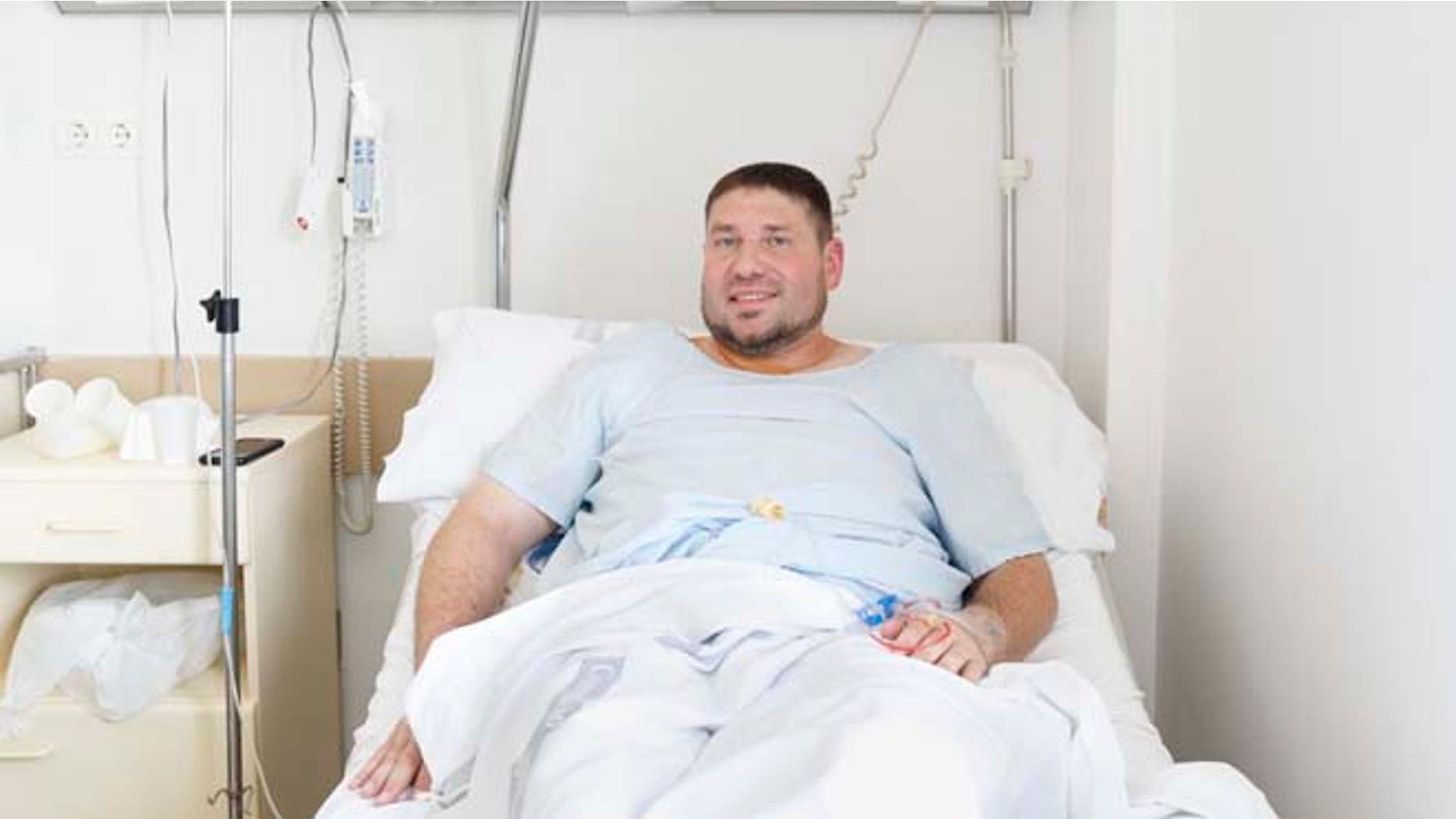 Mike Webster, a 38-year-old occupational therapist from Gainesville, Florida, who was gored in the armpit while running with the bulls in Pamplona for the 38th time over the last 11 years, poses for a picture on his hospital bed in Pamplona, Spain, Tuesday, July 7, 2015. Two Americans and a Briton were gored and eight others injured Tuesday as thousands of daredevils dashed alongside fighting bulls through the streets of this northern Spanish city on the first bull run of the San Fermin festival (AP Photo/Daniel Ochoa de Olza)