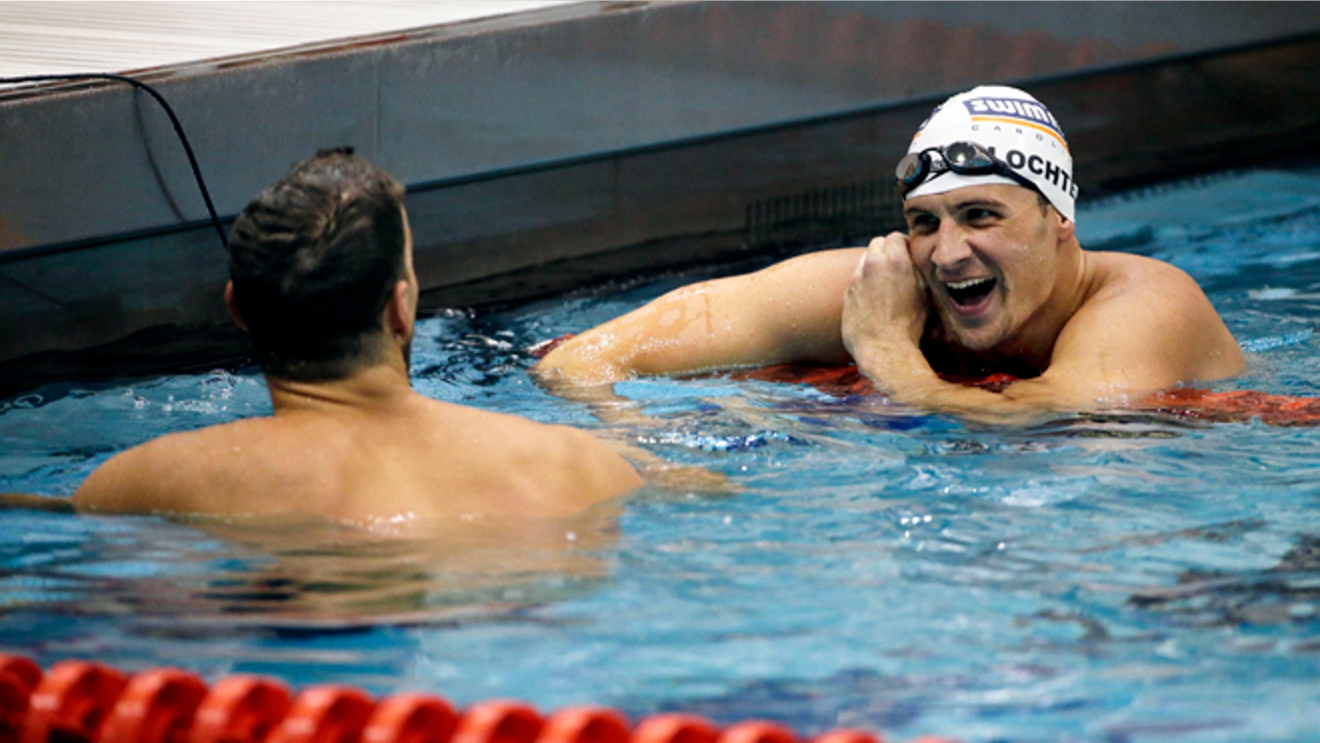 Michael Phelps, left, talks with Ryan Lochte, right, after Phelps beat Lochte to win the men's 100-meter backstroke at the Bulldog Grand Slam swim meet at the University of Georgia, Saturday, July 12, 2014, in Athens, Ga. Lochte took second place in the event. (AP Photo/David Goldman)