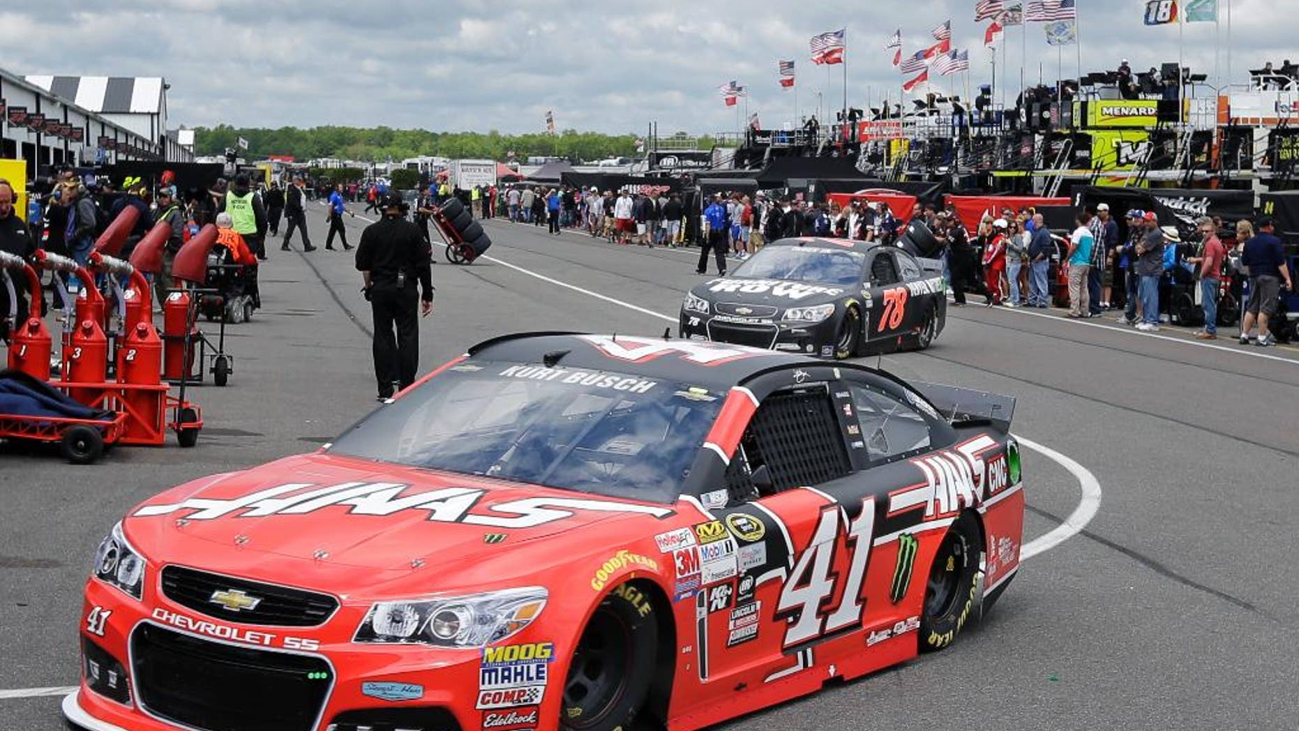 Kurt Busch (14) and Martin Truex Jr. (78) drive through the garage area at Pocono Raceway during practice for Sunday's NASCAR Sprint Cup Series auto race in Long Pond, Pa., Saturday, June 6, 2015. (AP Photo/Mel Evans)