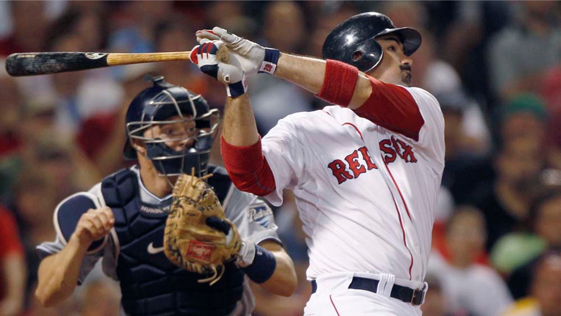 Boston Red Sox Adrian Gonzalez, right, and San Diego Padres catcher Nick Hundley watch Gonzalez's RBI double, breaking a 3-3 tie, in the bottom of the seventh inning of an interleague baseball game at Fenway Park in Boston, Monday, June 20, 2011. (AP Photo/Charles Krupa)