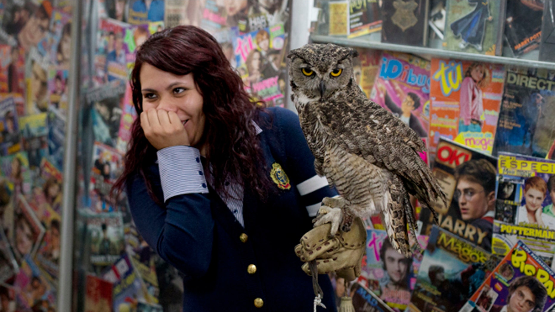 A Harry Potter fan reacts after a live owl bites her, inside an exhibition of the Guinness World Record holding collection of Harry Potter memorabilia, at the Mexican Museum of Antique Toys, in Mexico City, Friday, Feb. 27, 2015. Mexico's fan Menahem Asher Silva Vargas assembled the collection, which contains thousand objects, including figurines, wands, magazines, puzzles, and accessories. (AP Photo/Rebecca Blackwell)