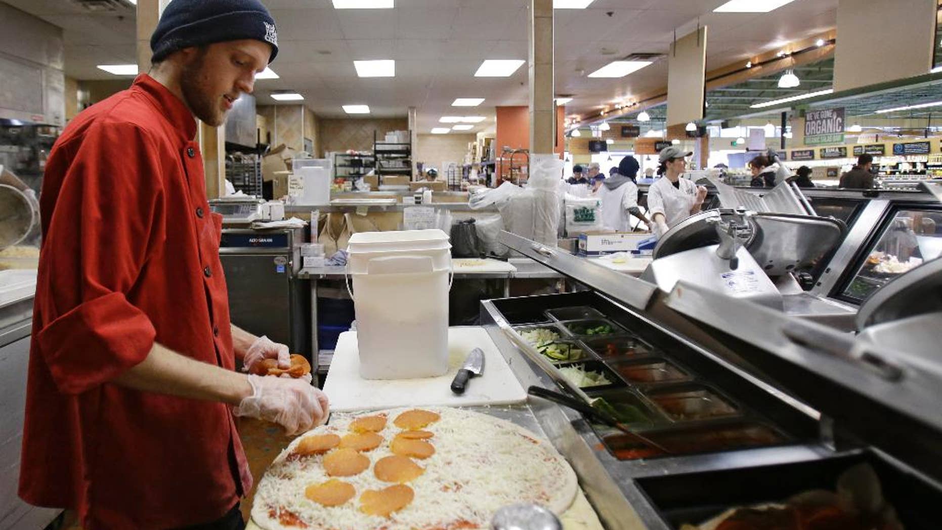 In this Thursday, March 27, 2014 John Pittenger makes a pepperoni pizza at the Whole Foods Market in Woodmere Village, Ohio. The Institute for Supply Management releases its service sector index for April 2015 on Tuesday, May 5, 2015. (AP Photo/Tony Dejak)