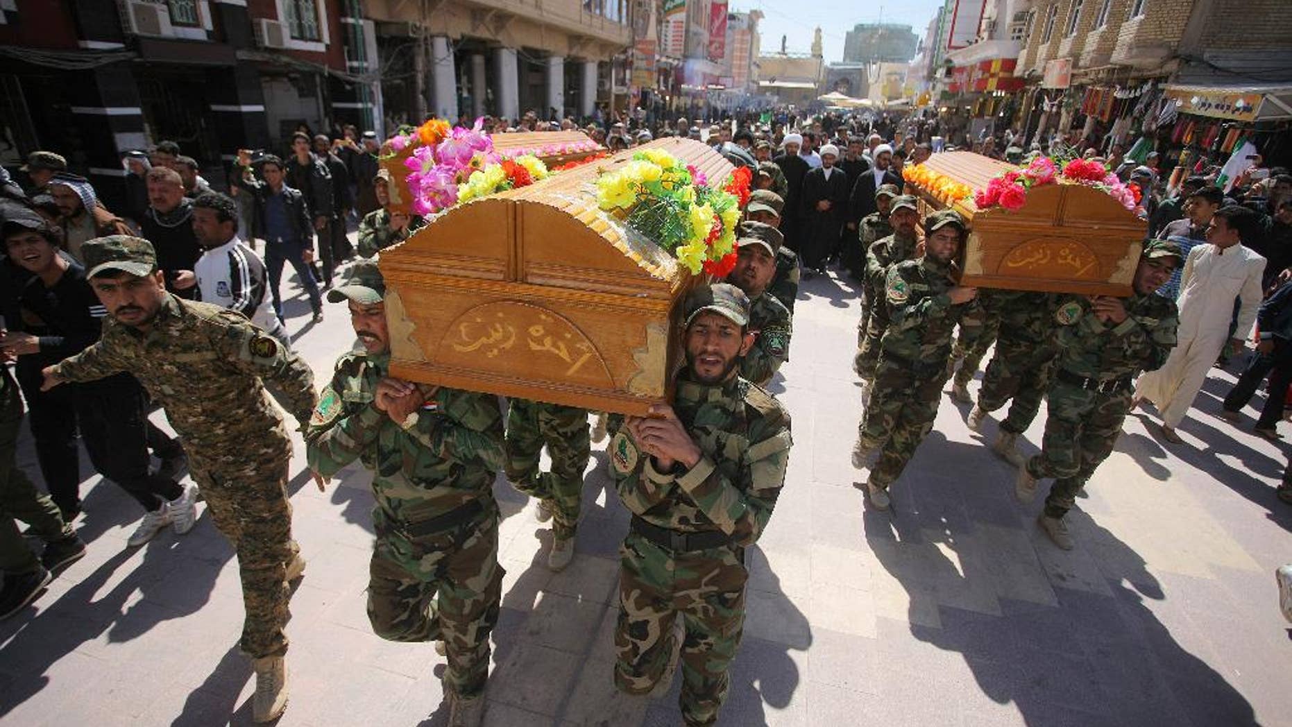 Mourners chant slogans against the Islamic State group during the funeral procession of three members of a Shiite group, Asaib Ahl al-Haq, or League of the Righteous, who were killed in Tikrit while fighting Islamic militants, in Najaf, 100 miles (160 kilometers) south of Baghdad, Iraq, Wednesday, March 11, 2015. Iranian-backed Shiite militias and Sunni tribes have joined Iraq's military in a major operation to retake Tikrit from the Islamic State group. (AP Photo/Jaber al-Helo)