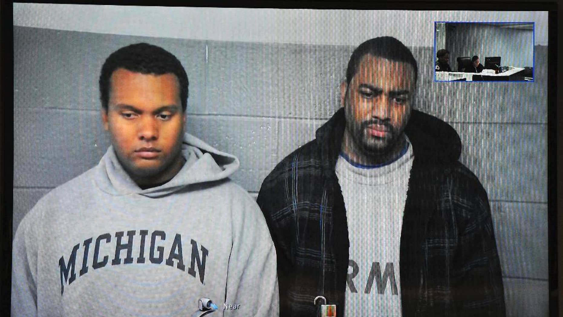 FILE- in this file image from Oct. 27, 2015, taken from video provided by the 36th District Court, Detroit police officers Charles Lynem, 28, left, and Chancellor Searcy, 31, are arraigned via video conference in Detroit. Detroit Police Chief James Craig says the two members of an elite police unit can return to work after being acquitted of stealing money from people they stopped on the street. A jury acquitted Officers Lynem and Searcy on Jan. 11, 2017. They had been suspended without pay. (Wayne County District Court/Detroit News via AP)