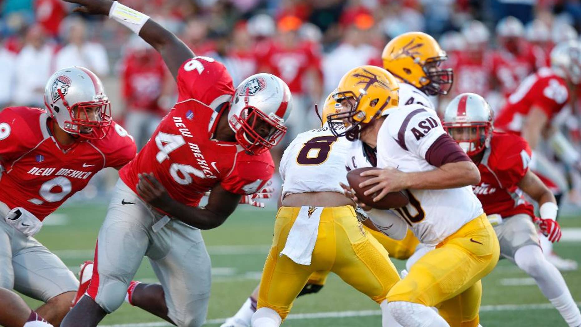 Arizona State's Taylor Kelly, right, runs away from the pressure by New Mexico's Paytron Hightower (46) during the first half of an NCAA college football game Saturday, Sept. 6, 2014, in Albuquerque, N.M. Arizona State defeated New Mexico 58-23. (AP Photo/Ross D. Franklin)