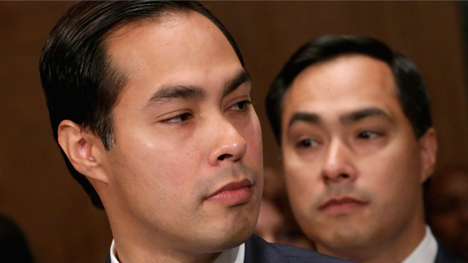WASHINGTON, DC - JUNE 17: Mayor Julian Castro (L) testifies during his confirmation hearing before the Senate Banking, Housing and Urban Affairs Committee with his twin brother, Rep. Joaquin Castro (D-TX), in the background June 17, 2014 in Washington, DC. The current mayor of San Antonio, Texas, Castro has not faced serious opposition in the Senate. (Photo by Chip Somodevilla/Getty Images)