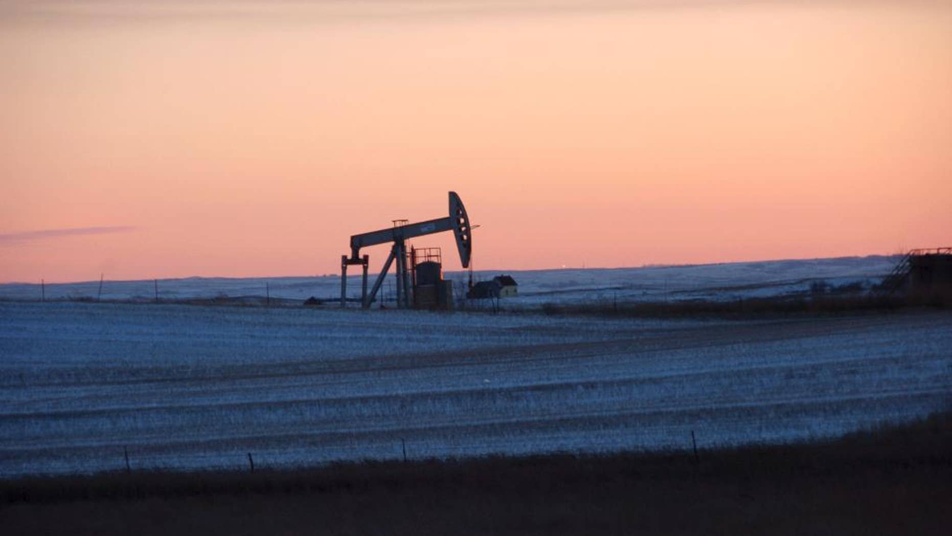 FILE - This Feb. 25, 2015, file photo, shows a pump jack for pulling oil from the ground, near New Town, N.D. On Tuesday, Nov. 8, 2016, the Energy Department said it is raising its forecast of U.S. production for both 2016 and 2017, as drillers respond to higher crude prices. Still, output won’t match 2015, which was the biggest year for U.S. production in 35 years. (AP Photo/Matthew Brown, File)