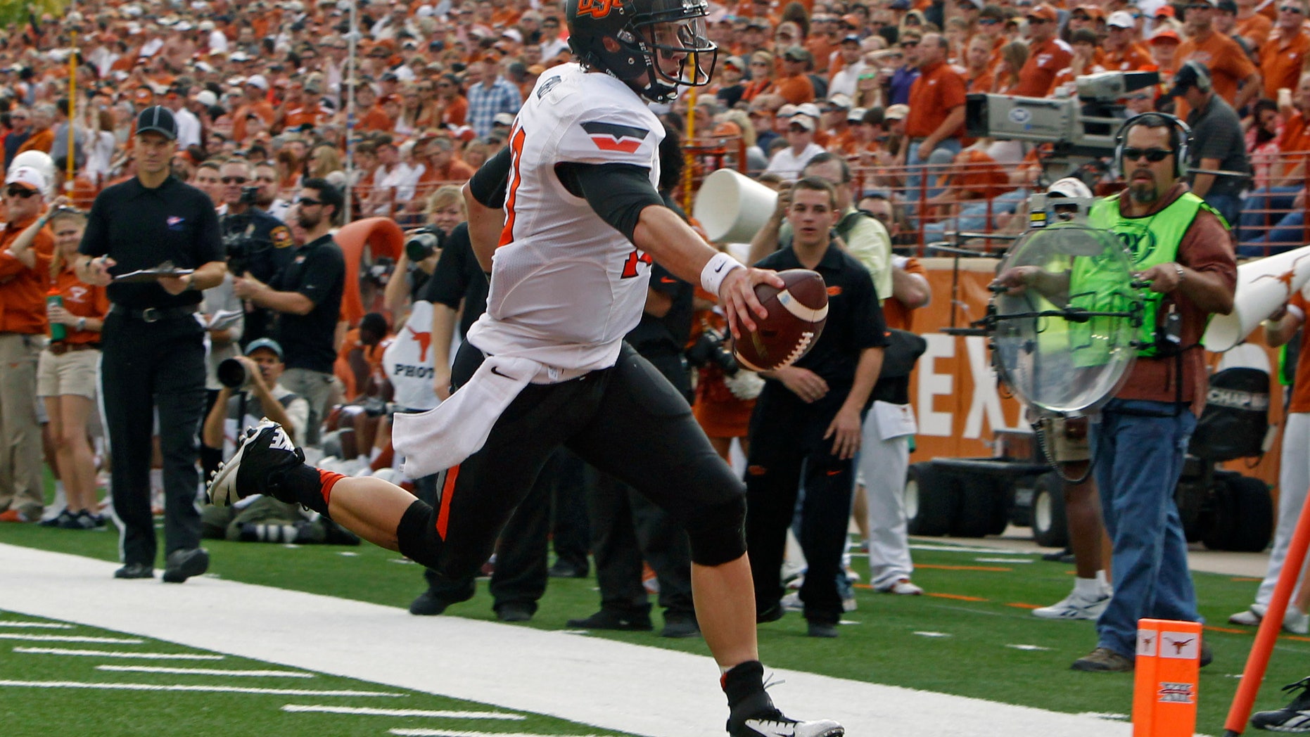 Oklahoma State quarterback Clint Chelf scores a touchdown against Texas during the second quarter of an NCAA college football game Saturday, Nov. 16, 2013, in Austin, Texas. (AP Photo/Michael Thomas)