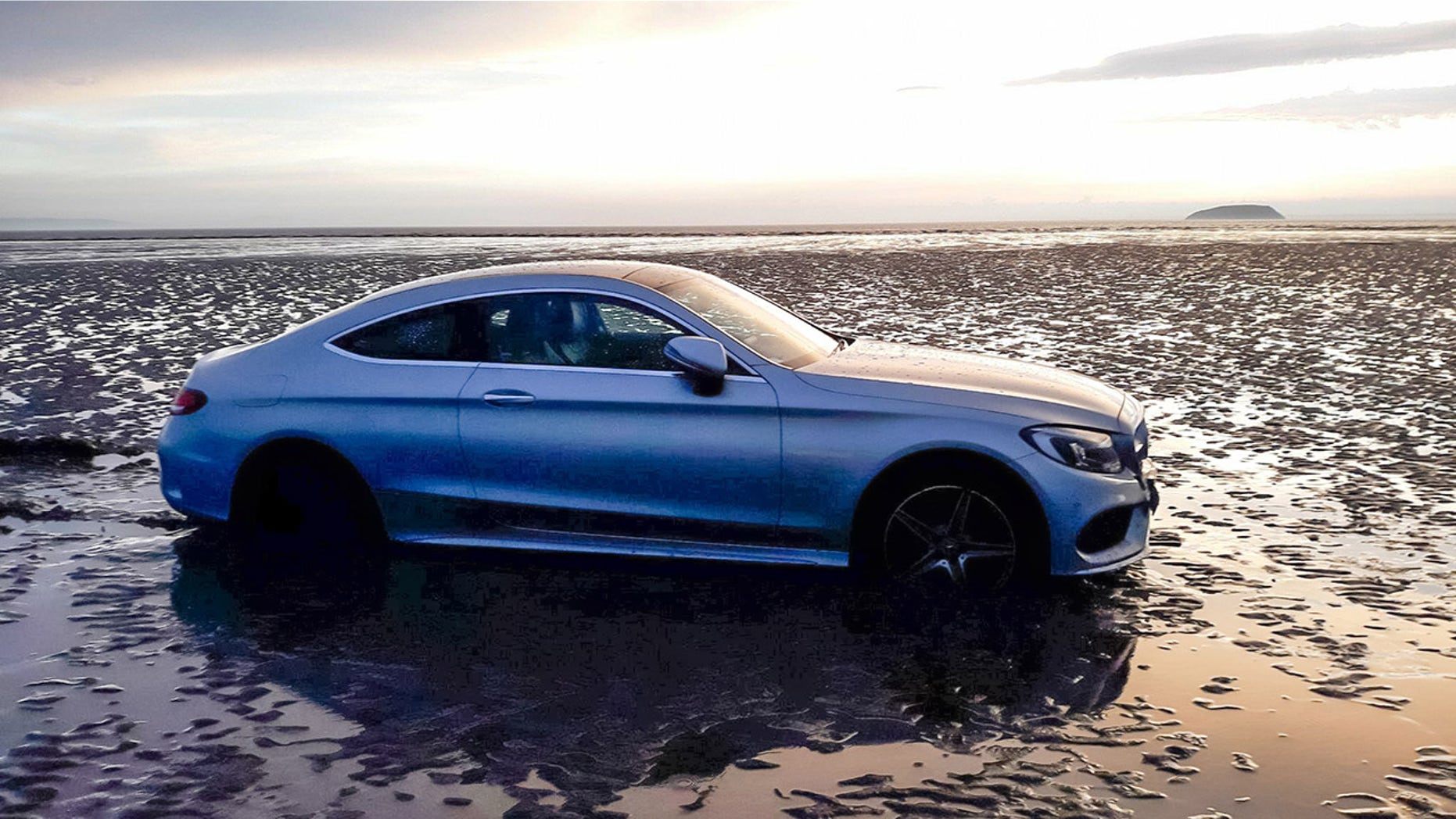 Please note mandatory credit - Burnham Coastguard Rescue Team / SWNS
A man died of a heart attack as he tried to rescue this Mercedes from a beach. See SWNS story SWRESCUE; The member of the rescue team was trying to move a hire car wedged in mud. The vehicle had been rented by a couple and become stranded at Burnham-on-Sea in Somerset. A Coastguard team and a local commercial vehicle recovery service were called out to recover the Mercedes on Saturday as the tide moved in.