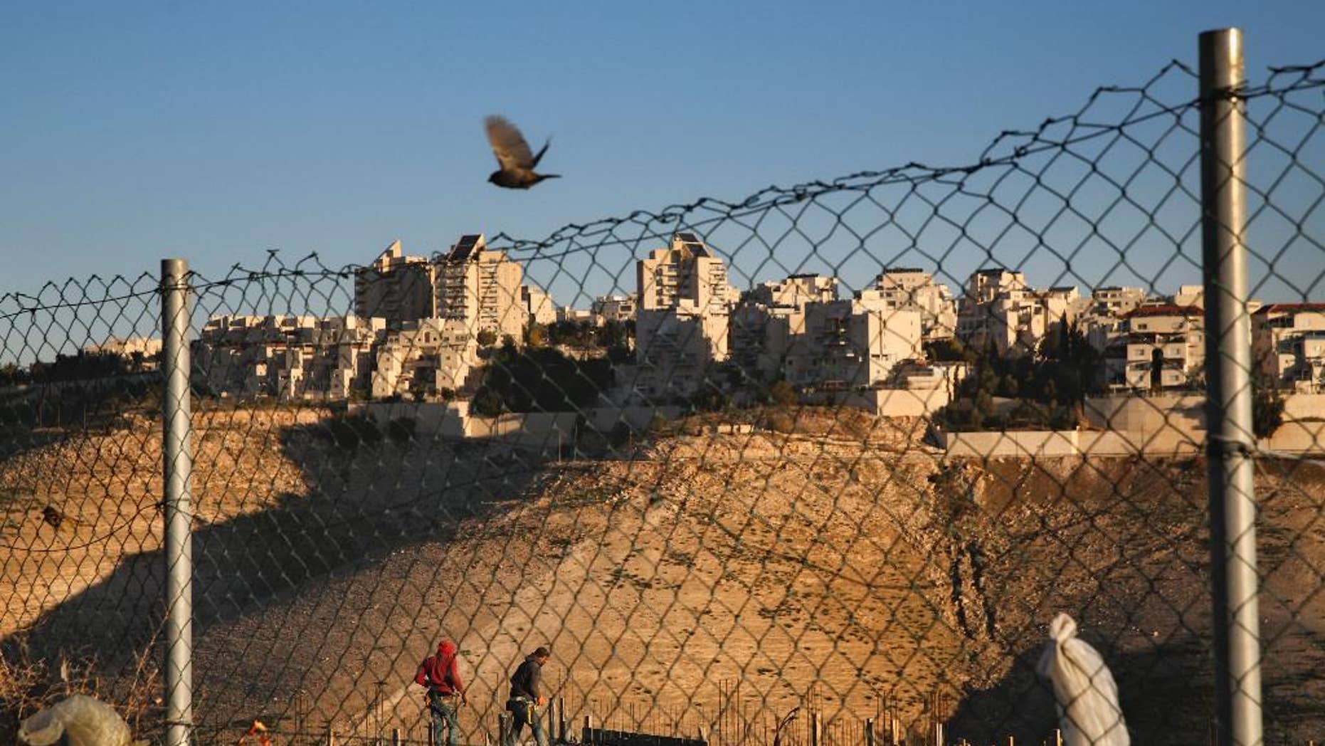 Palestinian laborers work at a construction site in a new housing project in the Israeli settlement of Maale Adumim, near Jerusalem, Tuesday, Feb. 7, 2017. A Palestinian Cabinet minister on Tuesday called on the international community to punish Israel for a contentious new law, just hours after the Israeli parliament adopted the bill to retroactively legalize thousands of West Bank settlement homes built unlawfully on private Palestinian land.(AP Photo/Oded Balilty)