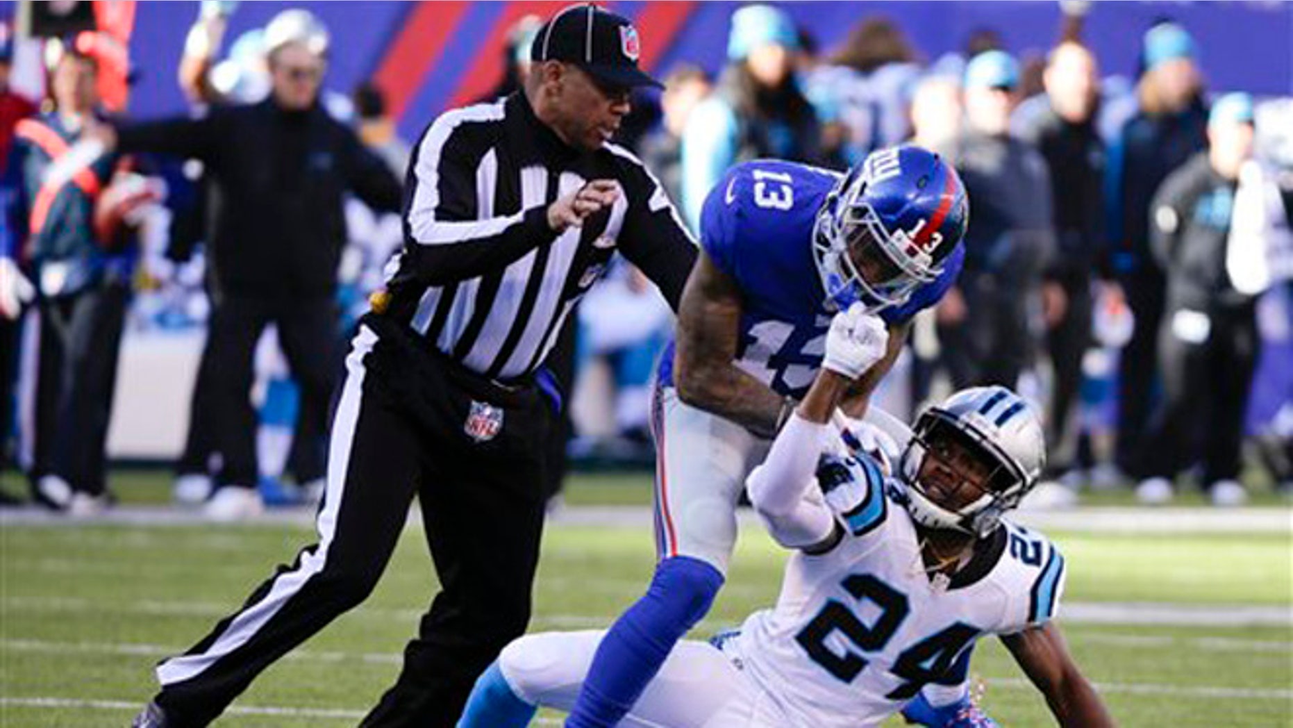 A referee, left, separates New York Giants wide receiver Odell Beckham (13) and Carolina Panthers' Josh Norman (24) during the first half of an NFL football game Sunday, Dec. 20, 2015, in East Rutherford, N.J. (AP Photo/Julie Jacobson)