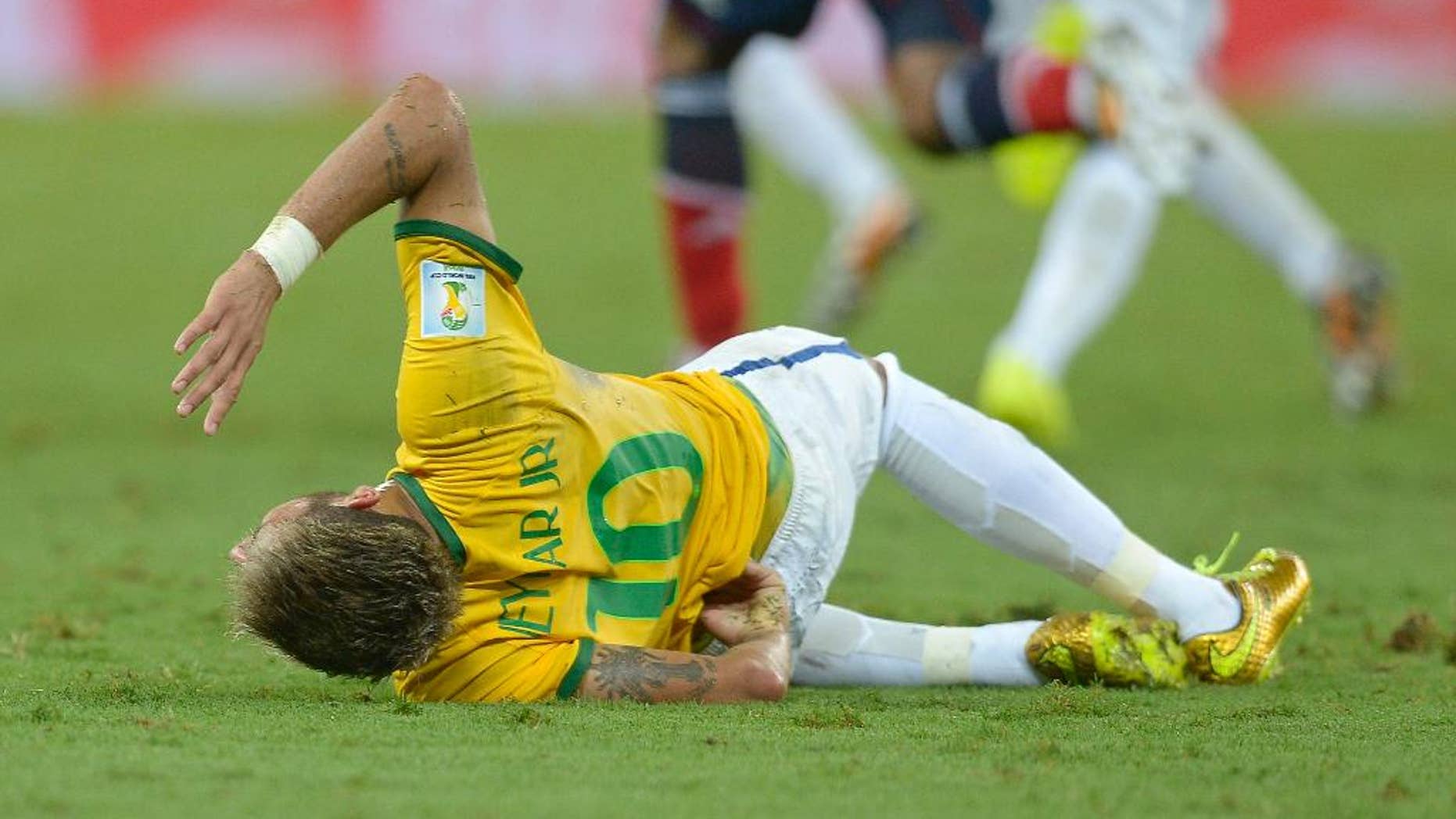 Brazil's Neymar holds his back after being fouled during the World Cup quarterfinal soccer match between Brazil and Colombia at the Arena Castelao in Fortaleza, Brazil, Friday, July 4, 2014. (AP Photo/Manu Fernandez)