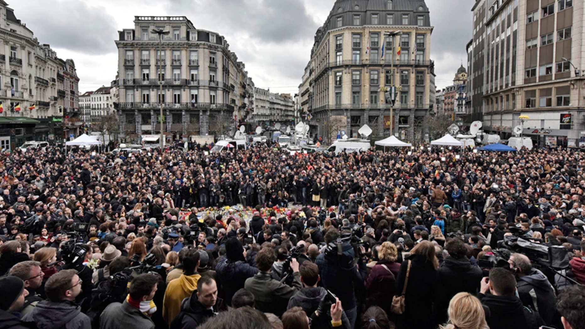 People observe a minute of silence at the Place de la Bourse in the center of Brussels, Wednesday, March 23, 2016. Bombs exploded yesterday at the Brussels airport and one of the city's metro stations Tuesday, killing and wounding scores of people, as a European capital was again locked down amid heightened security threats. (AP Photo/Martin Meissner)