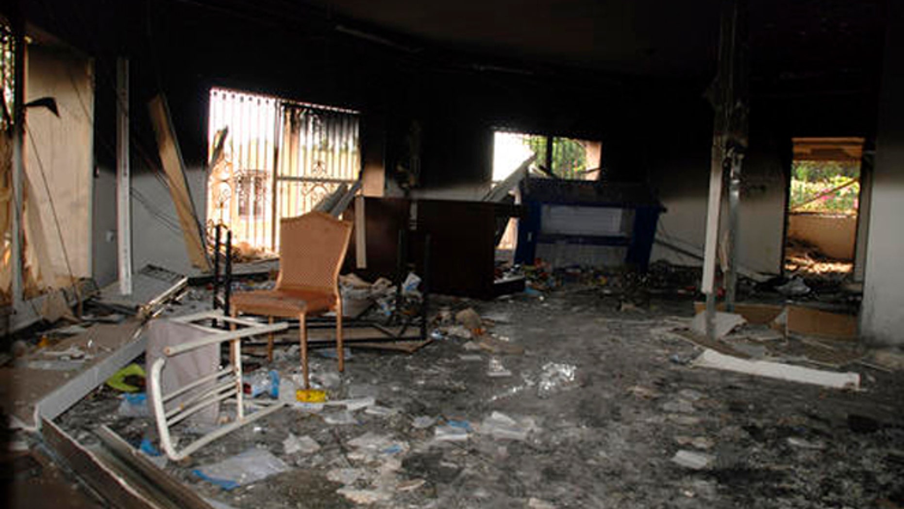 In this Sept. 12, 2012 file photo, glass, debris and overturned furniture are strewn inside a room in the gutted U.S. consulate in Benghazi, Libya, after an attack that killed four Americans, including Ambassador Chris Stevens.