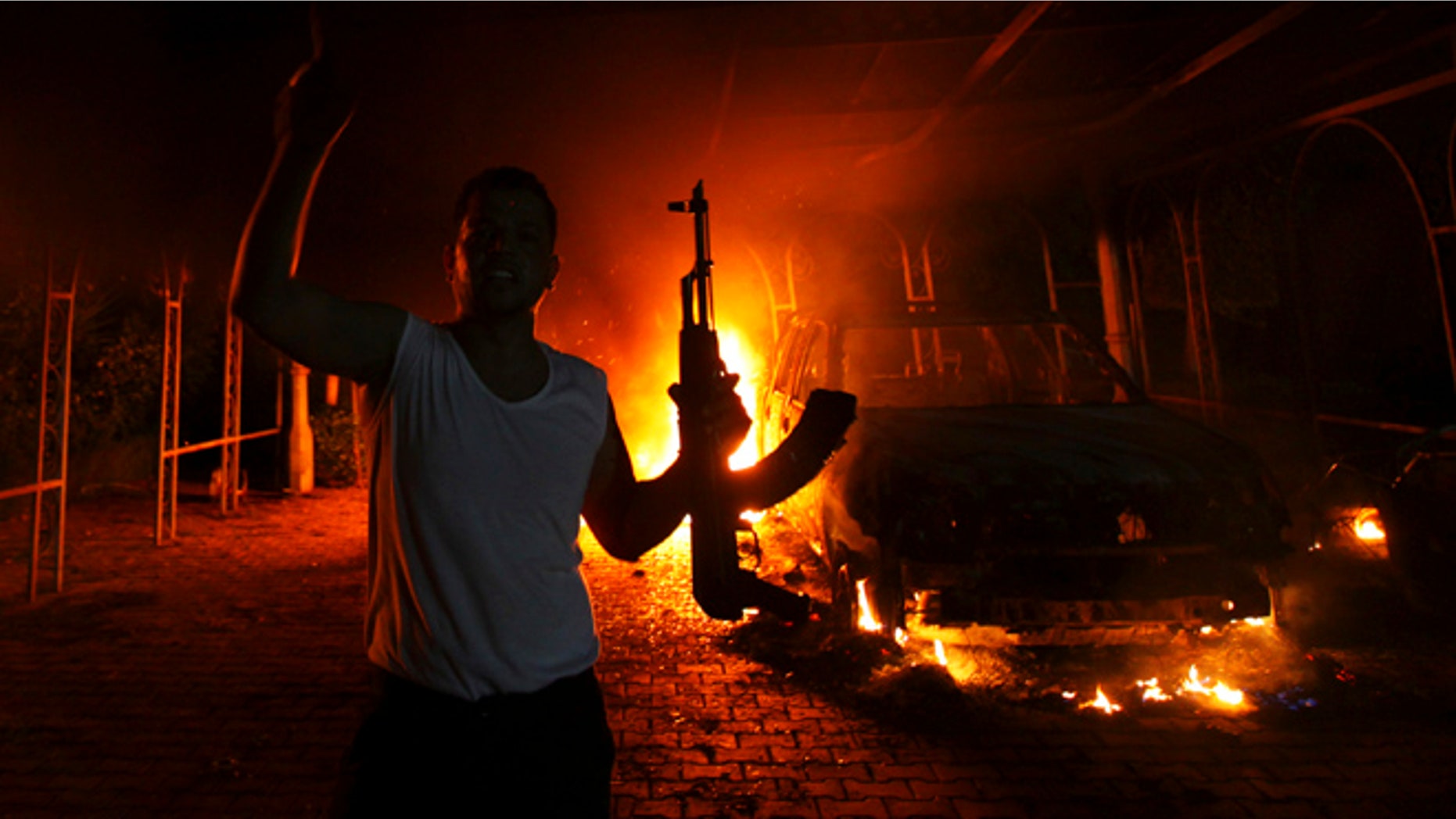 Sept. 11, 2012: A protester reacts as the U.S. Consulate in Benghazi is seen in flames during a protest by an armed group.