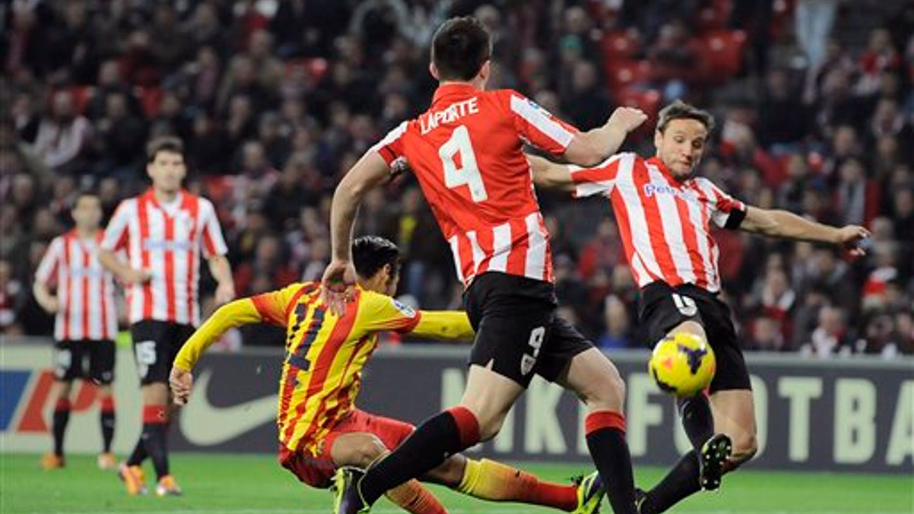 El brasileño Neymar, del Barcelona, a la izquierda, intenta anotar entre los jugadores del Athletic de Bilbao Aymeric Laporte y Carlos Gurpegui, a la derecha, durante un partido de la liga española en San Mamés, en Bilbao, España, el domingo 1 de diciembre de 2013. El Barcelona perdió 1-0. (AP Foto/Alvaro Barrientos)