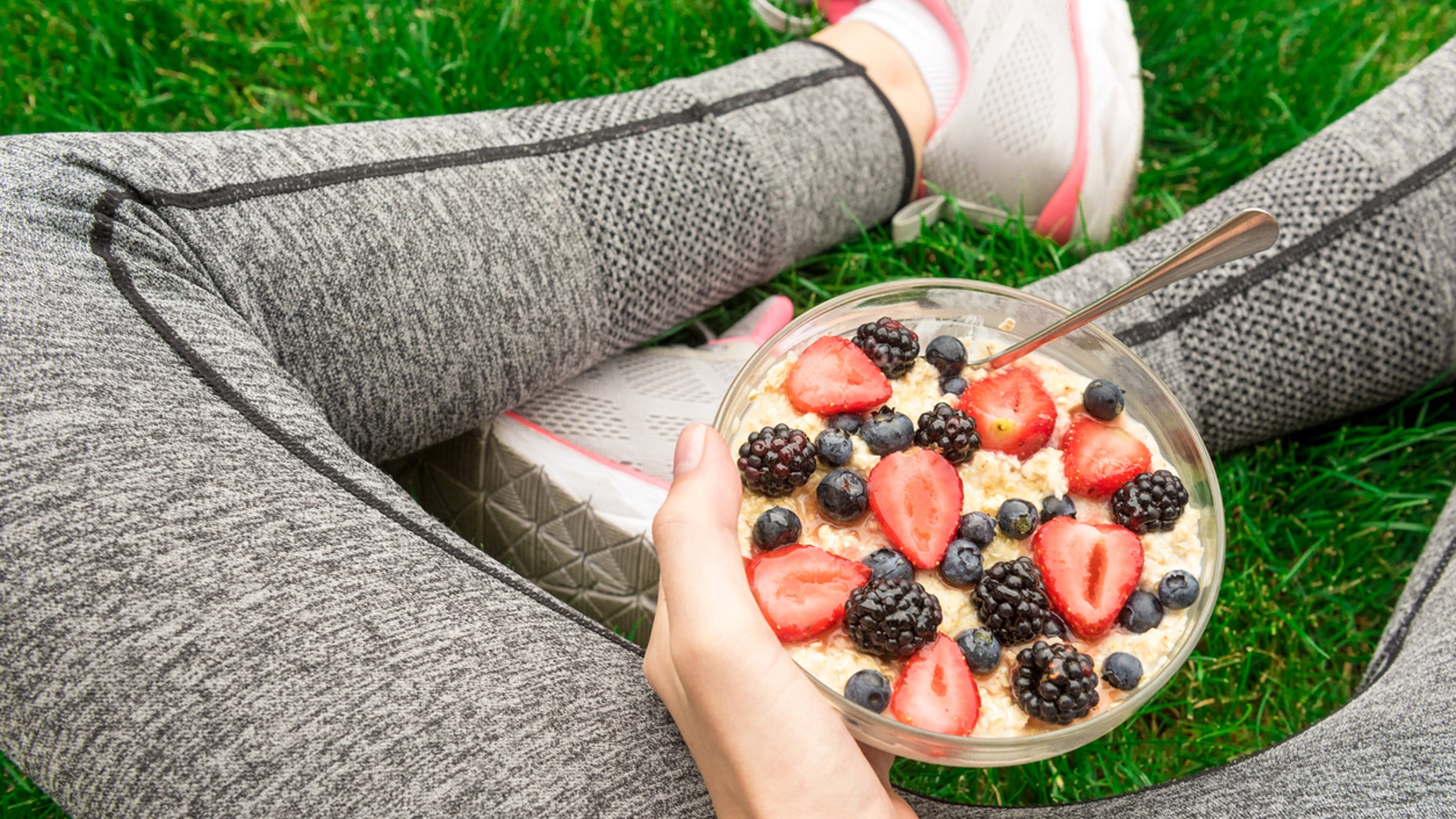 Young girl eating a oatmeal with berries after a workout . Fitness and healthy lifestyle concept.