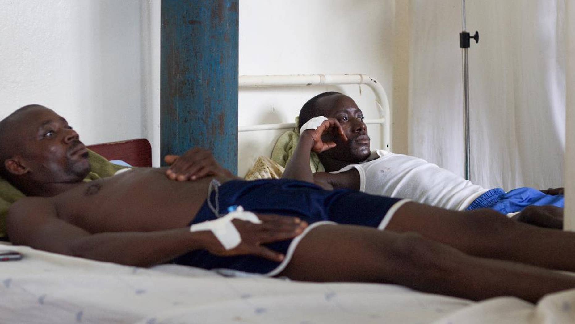 Two government soldiers, injured during Friday's fighting between the army and unidentified armed men, rest at the military hospital in Bujumbura, Burundi, Sunday, Dec. 13, 2015. Rights activists say that Friday's fighting, in which 87 people were killed in an escalation of the violence surrounding the disputed third term of President Pierre Nkurunziza, was the worst in months of turmoil since April when his candidacy was announced, and accused the security forces of extrajudicial killings of civilians. (AP Photo/Melanie Gouby)
