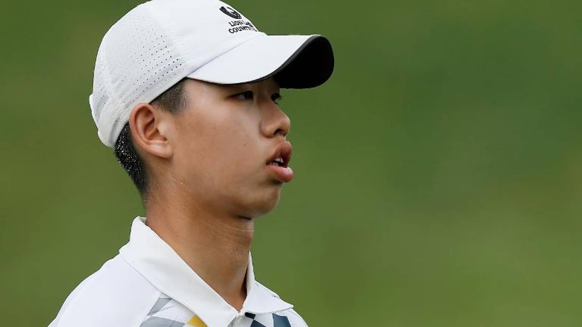 Guan Tianlang of China walks across the 17th green at Muirfield Village Golf Club on May 31, 2013 in Dublin, Ohio