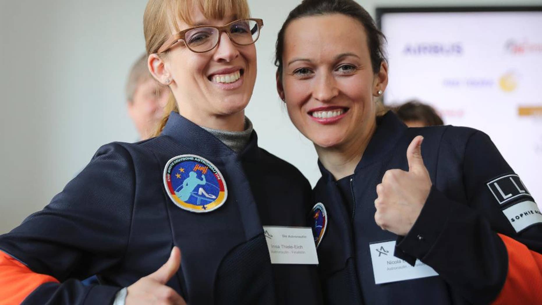 Insa Thiele-Eich, left, and Nicola Baumann give a thumb up sign in Berlin, Wednesday, April 19, 2017. A fighter pilot and a meteorologist have made the finals in the race to become Germany’s first female astronaut. A panel of experts picked the two finalists - German air force Eurofighter jet pilot Maj. Nicola Baumann and meteorologist Insa Thiele-Eich - from the top six candidates. (Michael Kappeler/dpa via AP)