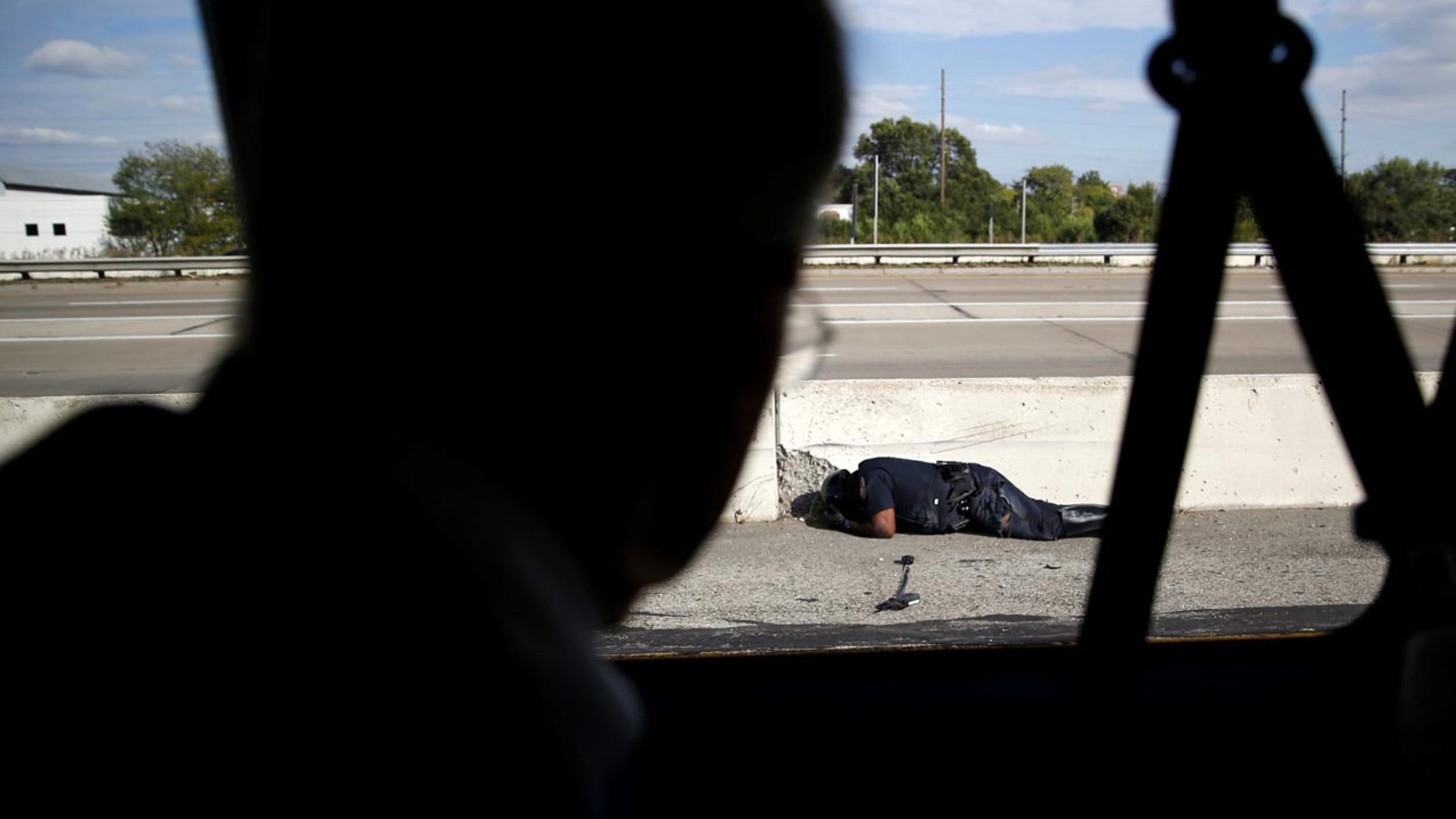 A police officer involved in an accident lies on the ground as President Trump's motorcade travels past him in Indianapolis, Sept. 27, 2017.