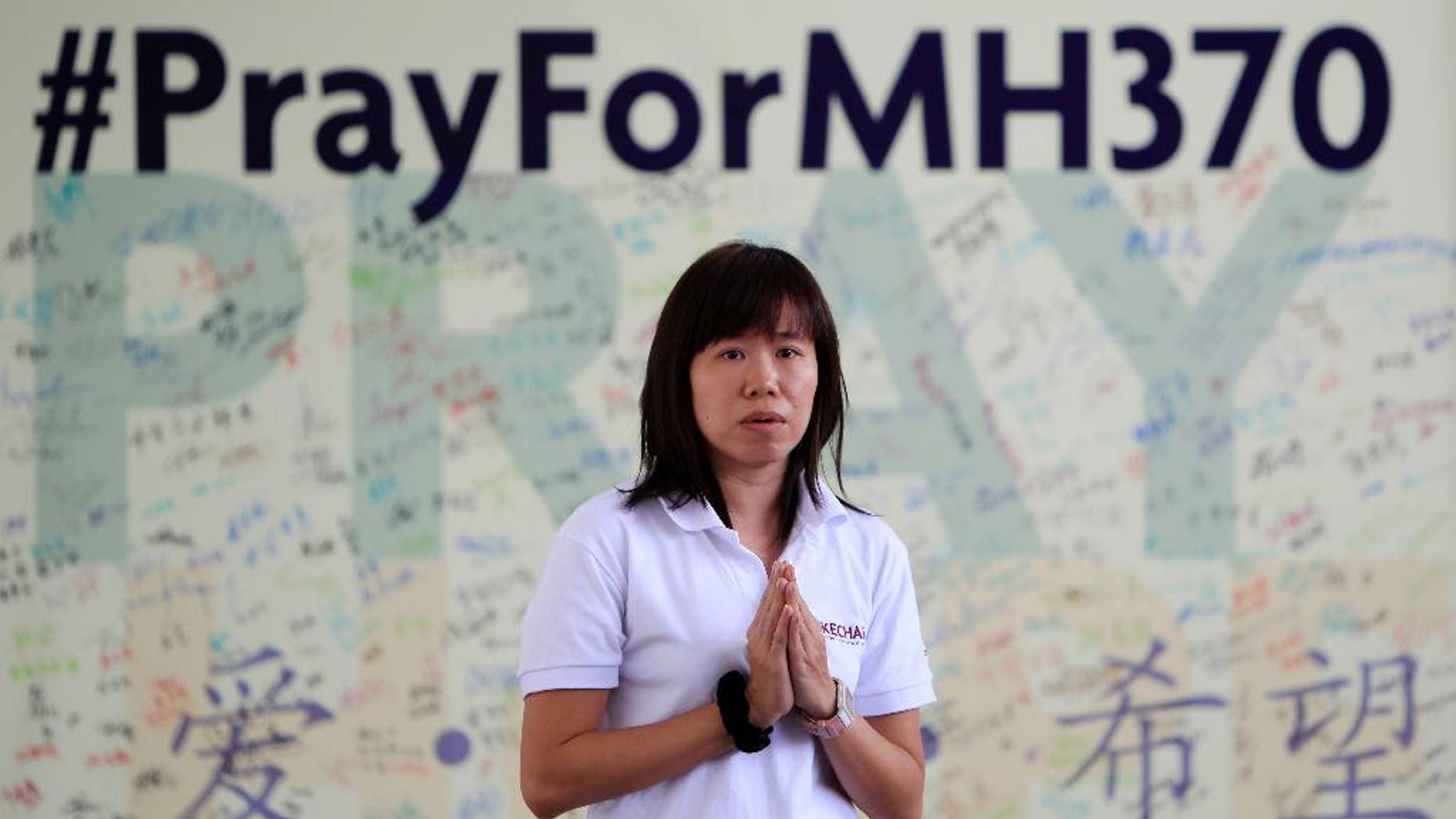 FILE - In this April 13, 2014 file photo, a member of Kechara Buddhist organization offers prayers for passengers onboard the missing Malaysia Airlines Flight 370 at Kechara Forest Retreat in Bentong, outside Kuala Lumpur, Malaysia. The hunt for Malaysia Airlines Flight 370 resumed Monday, Oct. 6, 2014 in a desolate stretch of the Indian Ocean, more than six months after the jet vanished. (AP Photo/Lai Seng Sin, File)