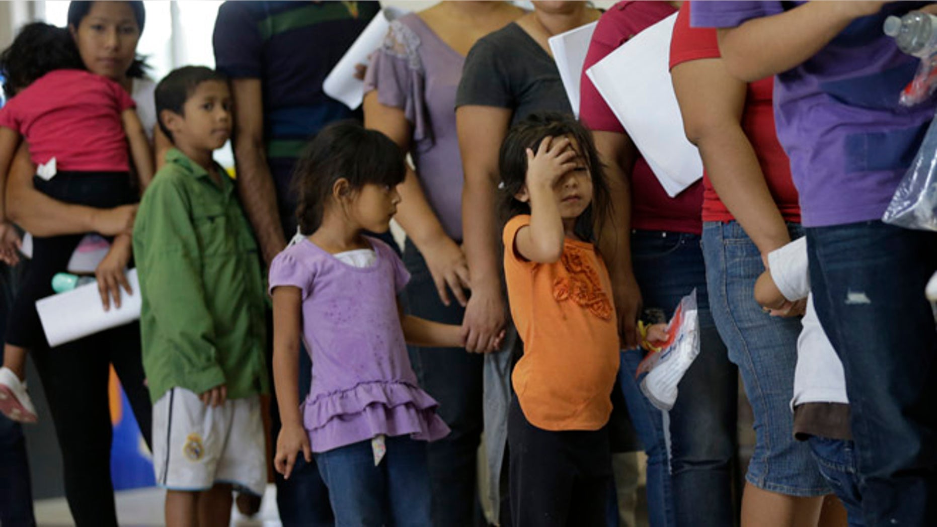 FILE - In this June 20, 2014 file photo, immigrants who entered the U.S. illegally stand in line for tickets at the bus station after they were released from a U.S. Customs and Border Protection processing facility in McAllen, Texas. Tackling what he has called a humanitarian crisis, President Barack Obama on Tuesday, July 8, 2014 asked Congress for $3.7 billion to cope with a tide of minors from Central America who are illegally crossing the U.S. border, straining immigration resources and causing a political firestorm in Washington. (AP Photo/Eric Gay, File)