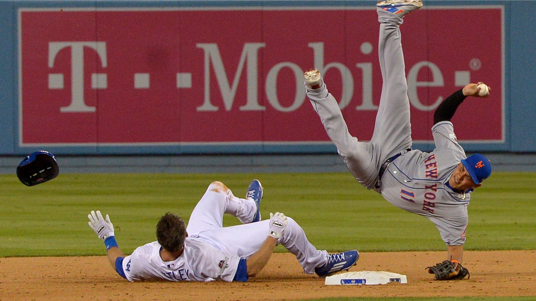 New York Mets shortstop Ruben Tejada falls after a slide by Los Angeles Dodgers' Chase Utley during the seventh inning of an NL Division Series baseball game Saturday, Oct. 10, 2015, in Los Angeles. (John McCoy/Los Angeles Daily News via AP)