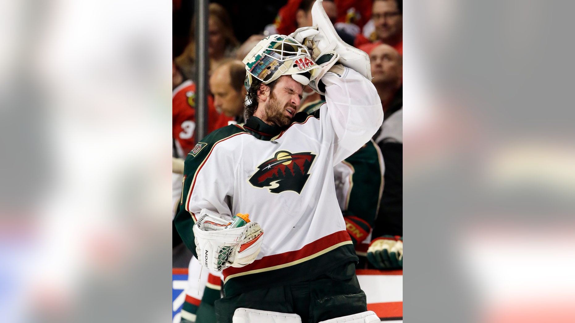 Minnesota Wild goalie Josh Harding puts on his helmet on during the second period of Game 2 of an NHL hockey Stanley Cup first-round playoff series against the Chicago Blackhawks in Chicago, Friday, May 3, 2013. (AP Photo/Nam Y. Huh)