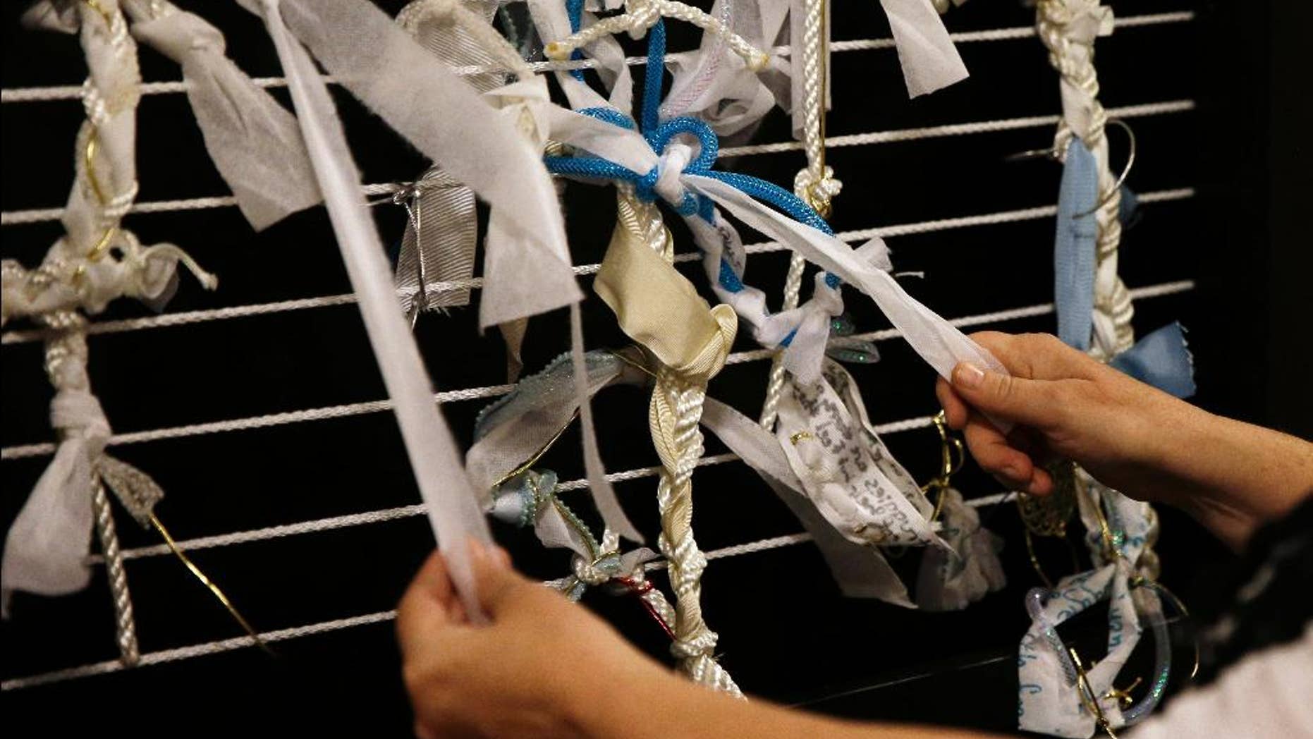 FILE- In this May 22, 2015 file photo, artist Meg Saligman shows knots tied to a mock-up of an art installation at her studio in Philadelphia. The installation is planned to be in the shape of a latticed grotto and will greet Pope Francis and millions of others when they travel to Philadelphia this fall. Visitors will be invited to leave their own problems behind in the form of knots affixed to its walls, or help others by loosening and removing a knot already in place. (AP Photo/Matt Slocum, File)