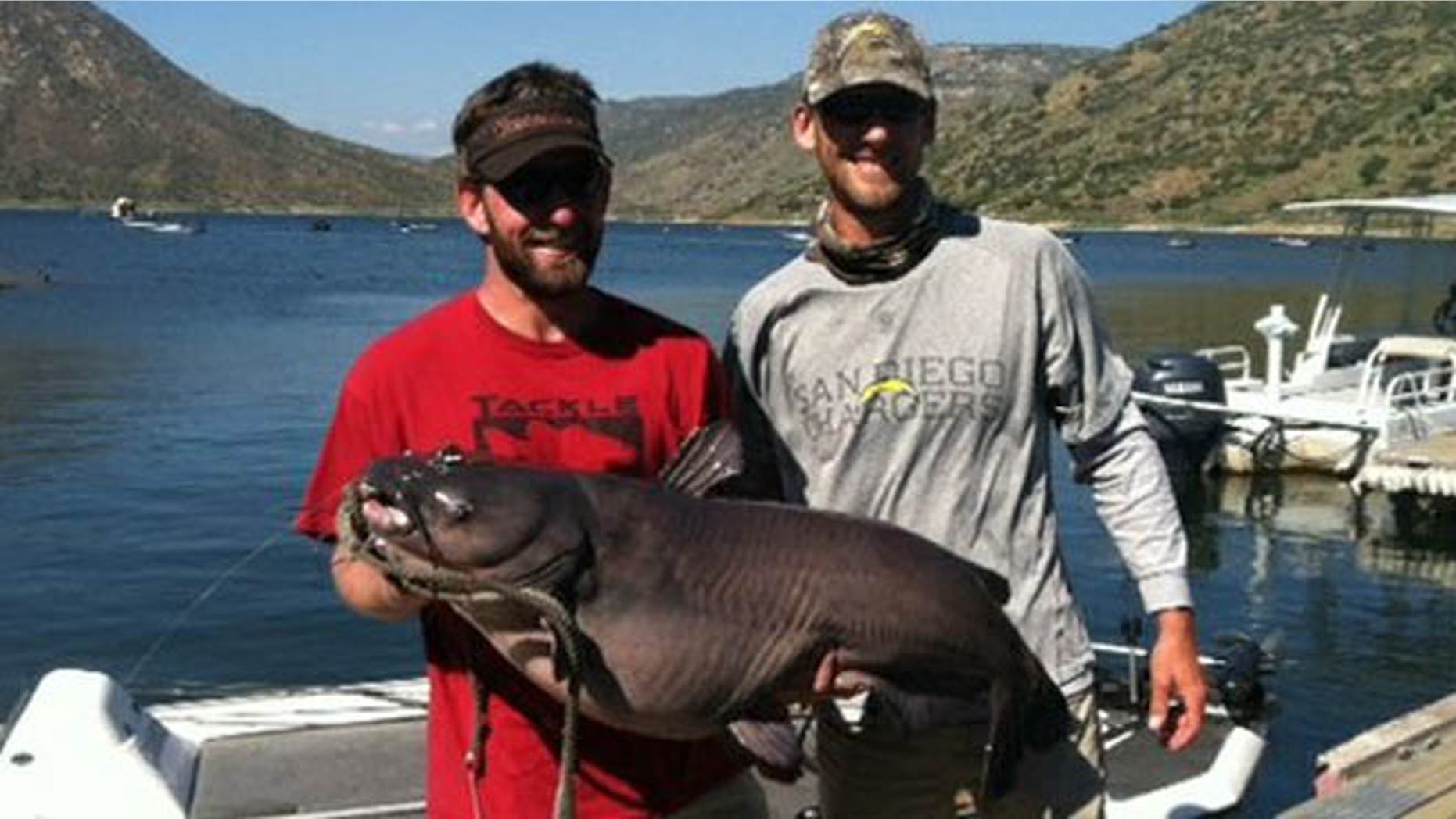 Cameron Smith left, holds his record-breaking blue catfish at El Capitan Reservoir.