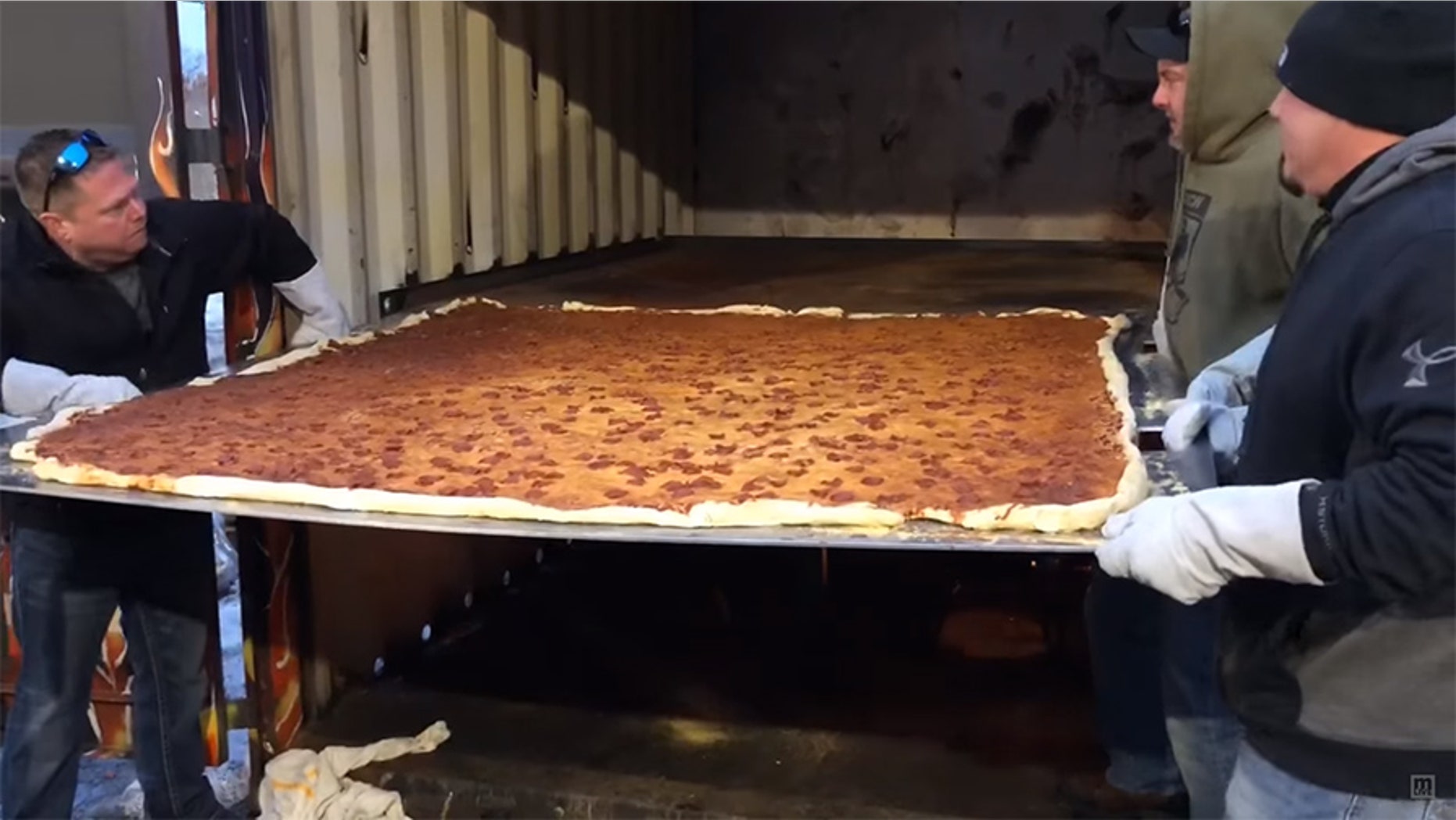 The six-foot-by-six-foot square pizza clocked in at 100 pounds of crust, sauce, cheese and pepperoni.