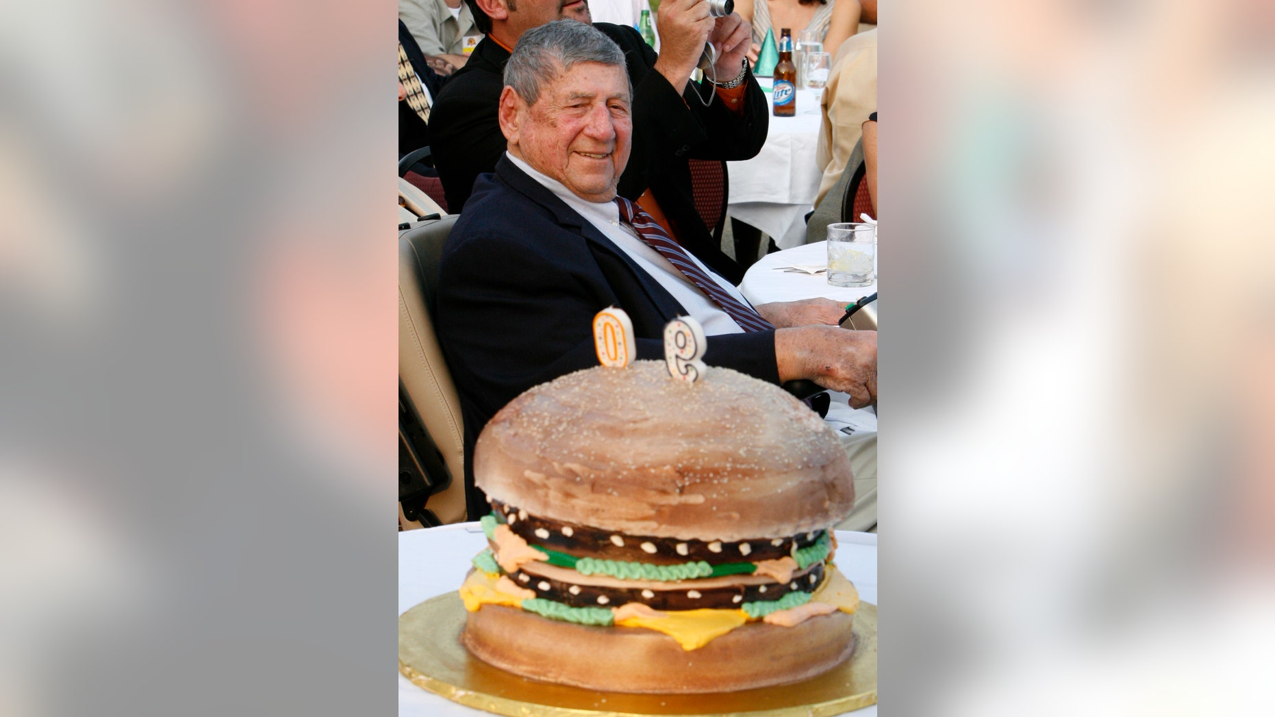 FILE - In this Aug. 21, 2008, file photo, Big Mac creator Michael "Jim" Delligatti sits behind a Big Mac birthday cake at his 90th birthday party in Canonsburg, Pa. Delligatti, the Pittsburgh-area McDonald's franchisee who created the Big Mac in 1967, has died. He was 98. (AP Photo/Gene J. Puskar, File)