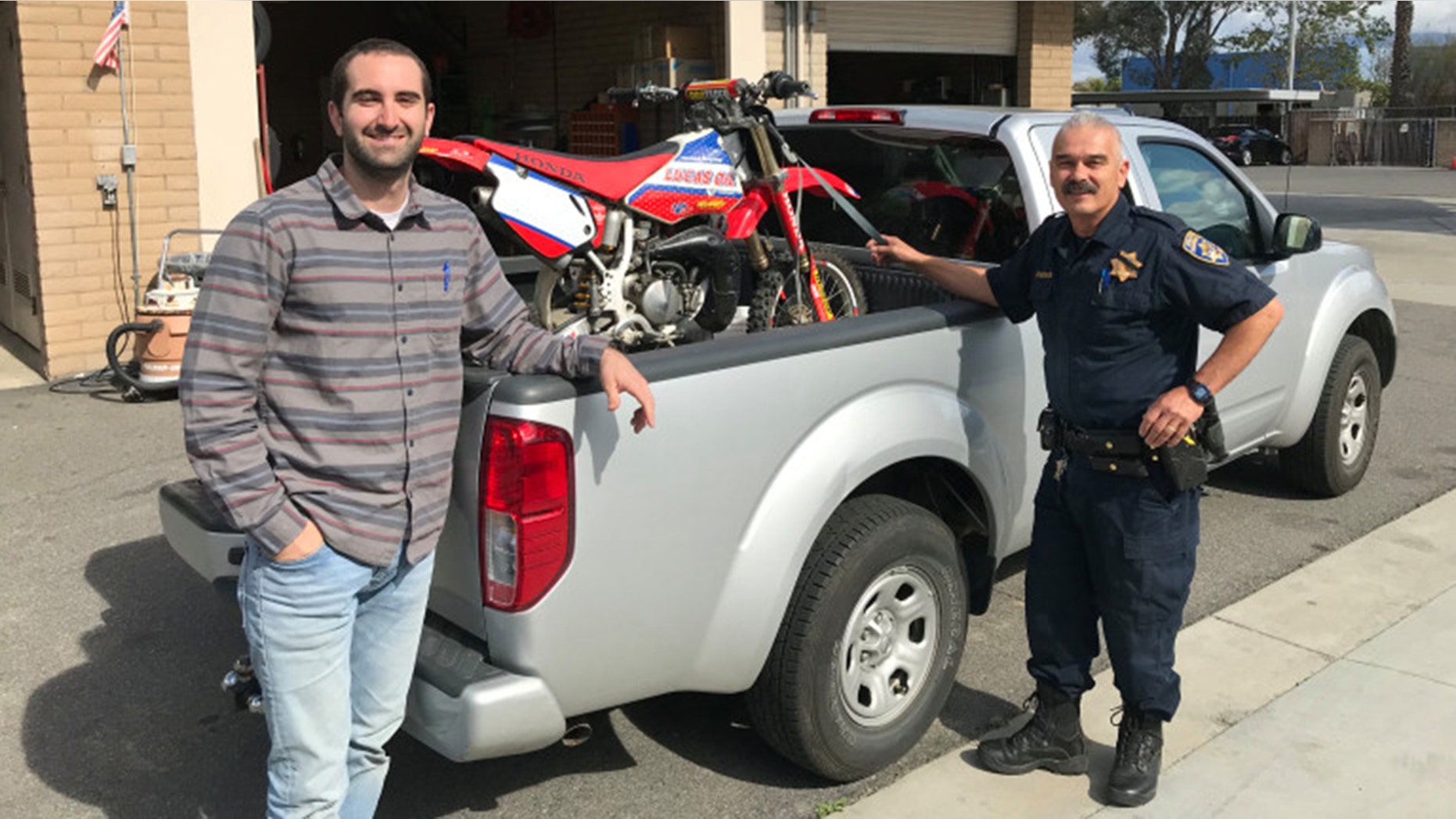 Kamron Golbaf retrieving his motorcycle from CHP officer Ralph Villegas at the Temecula station.