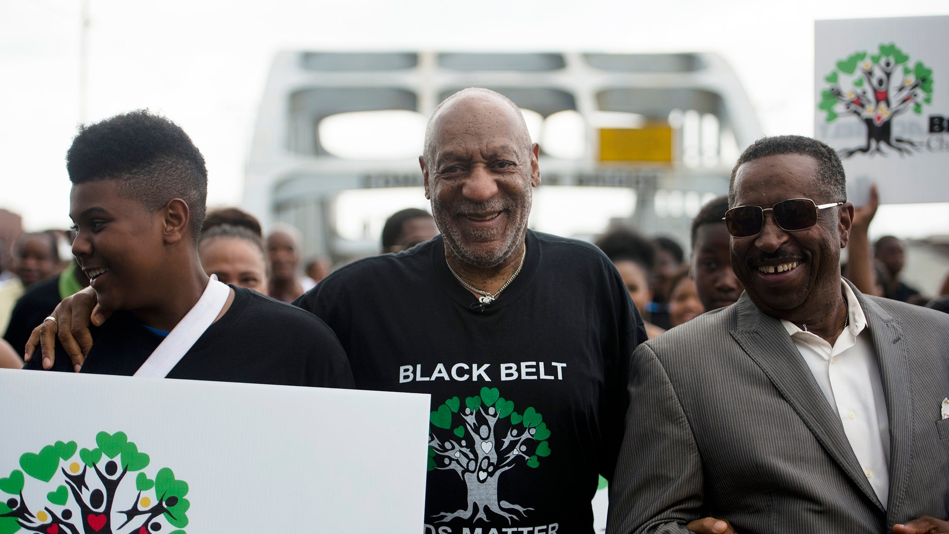 May 15, 2015. Bill Cosby, center, walks over the Edmund Pettus Bridge with Nysean Perkins, left, and Gregory Calhoun, Friday, May 15, 2015, in Selma, Ala. The march was arranged by The Black Belt Community Foundation as part of their "Black Belt Children Matter" campaign.