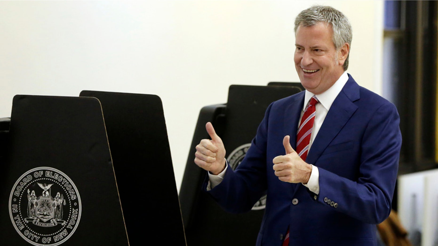 In this Nov. 7, 2017 photo, New York Mayor Bill de Blasio signals a double thumbs-up after voting at the Park Slope Library, in the Brooklyn borough of New York.