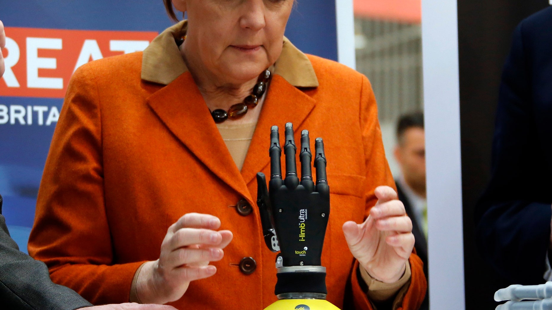File photo: German Chancellor Angela Merkel looks at a bionic hand during a tour at the CeBIT technology fair in Hanover March 10, 2014. (REUTERS/Fabrizio Bensch)