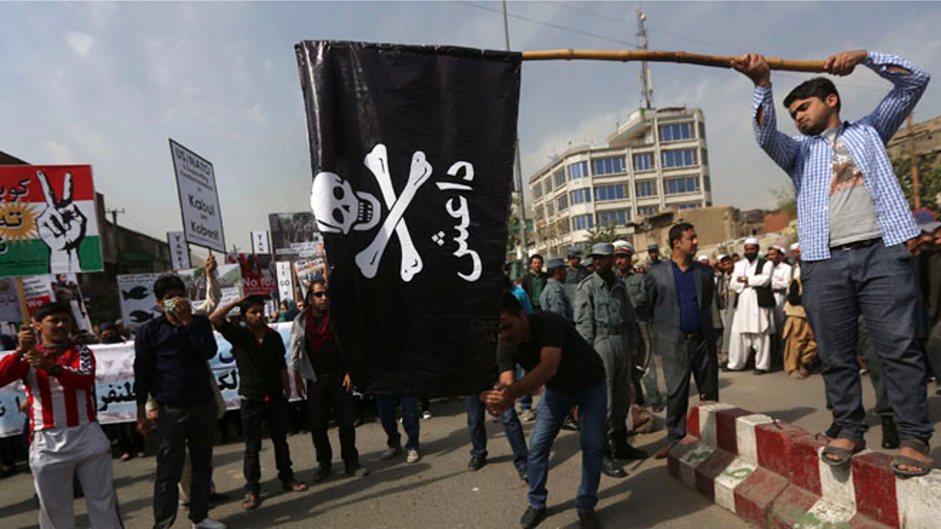 FILE: Oct. 12, 2014: Men prepare to set fire to an Islamic State flag during a protest in Kabul, Afghanistan.