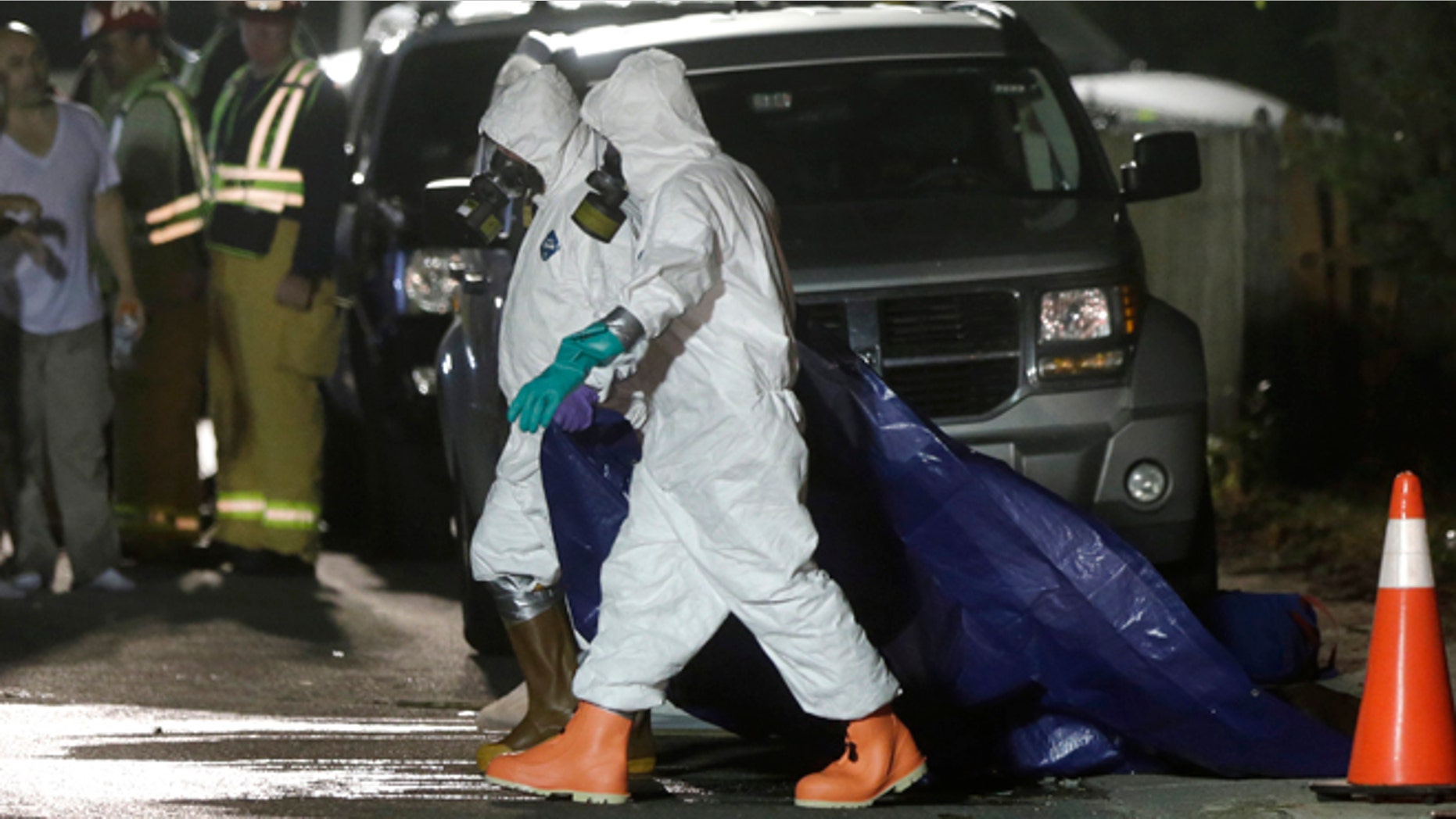 Sept. 11, 2014: Investigators in protective clothing drag a tarp across the street in front of a house where a Massachusetts prosecutor said the bodies of three infants were found in Blackstone, Mass. Worcester County District Attorney Joseph Early Jr. said Thursday authorities don't know when or how the babies died.