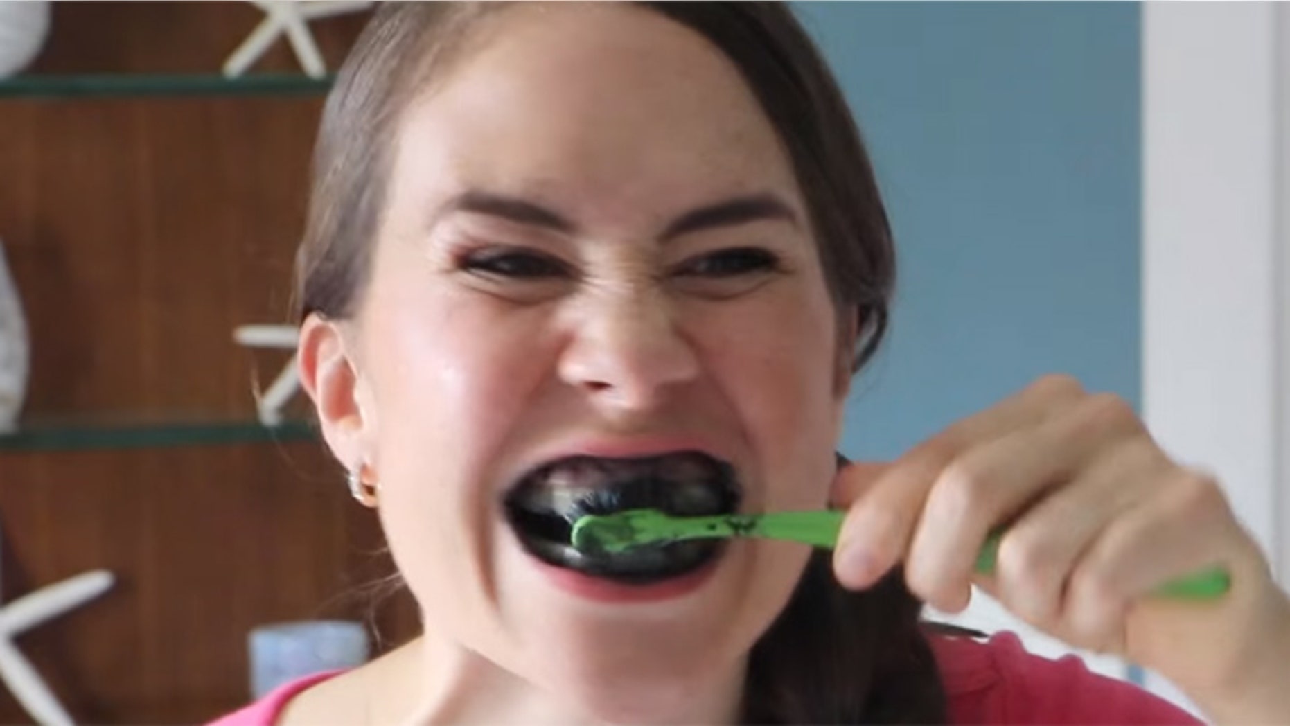 YouTube user "Mama Natural" uses activated charcoal to whiten her teeth.